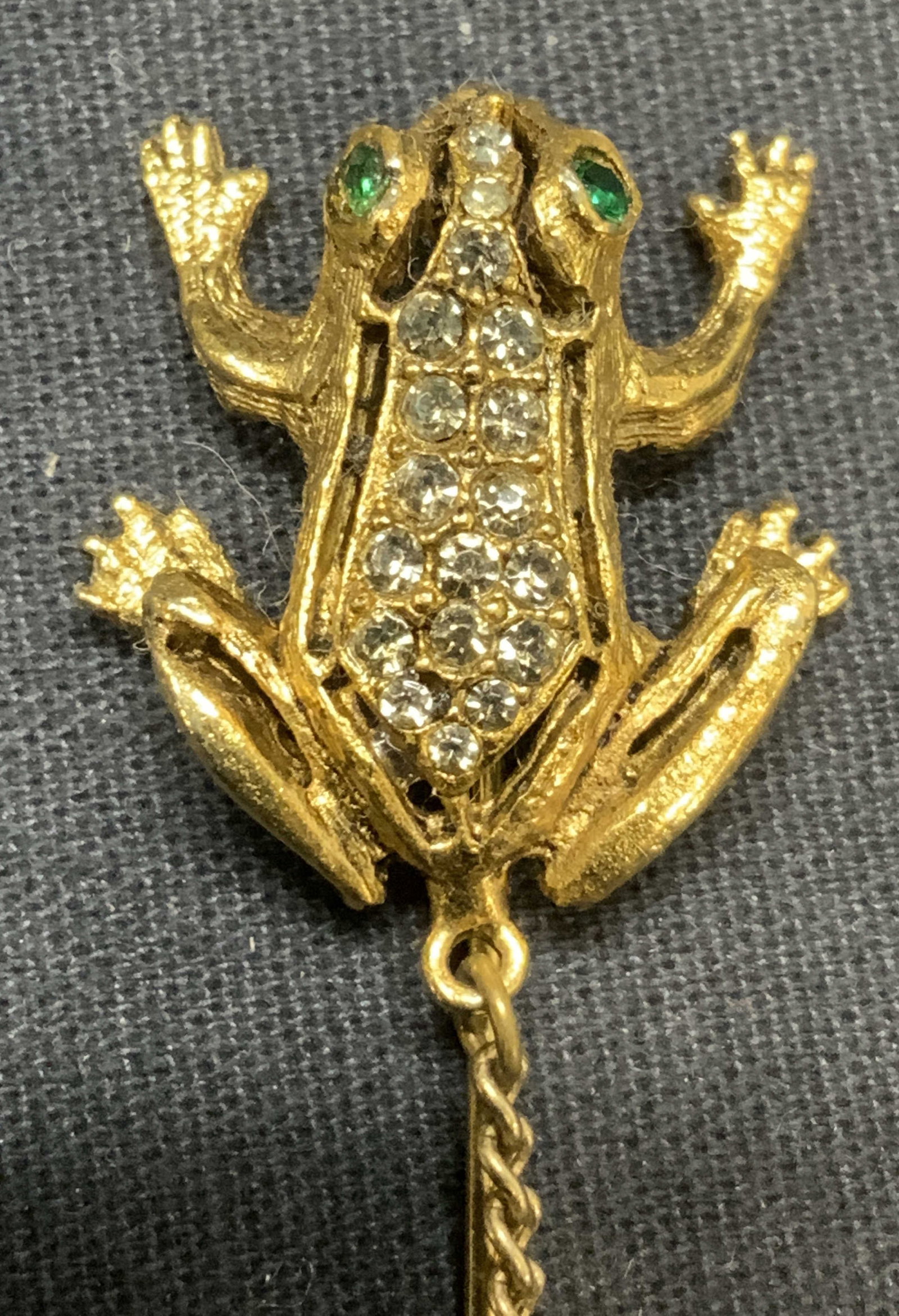 Vntg Pauline Rader Gold Tn Crystal Frog Stick Pin: Vintage Pauline Rader gold tone and crystal decorated stick pin to chain. Signed to underside. Pin measures approx. 2 7/8 inches long. Total length with chain approx. 4.5 inches. Some scratching obser