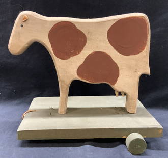 Hand Crafted Wooden Cow Folk Art Toy: Hand crafted wooden folk art toy cow on a platform with back wheels. Approx 10 inches tall and 10 x 8 inches wide platform Moderate surface wearing consistent with vintage age and use. Cow needs