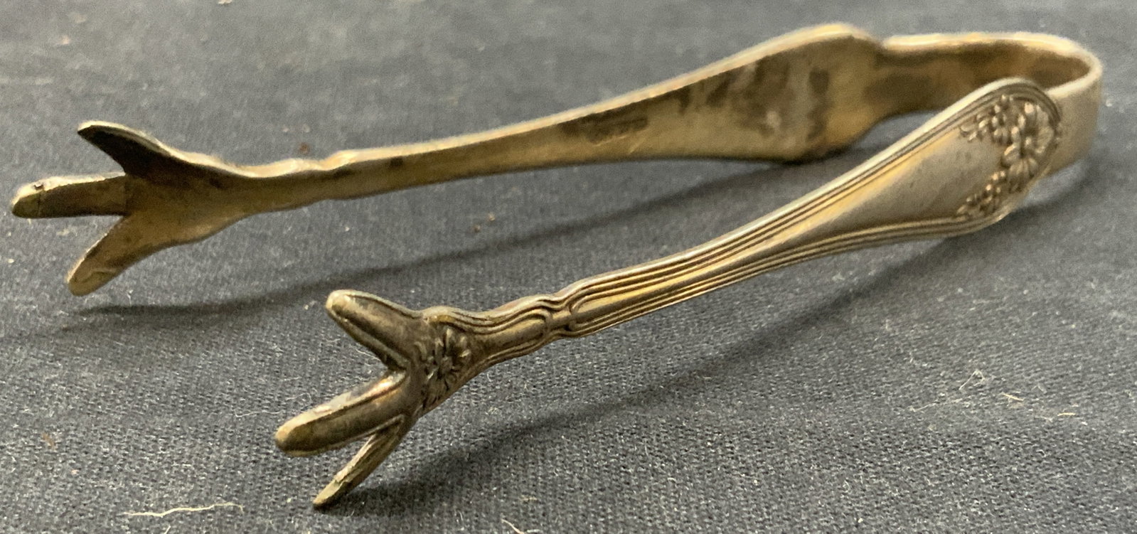 Antq W.M.Co Silver Plate Chicken Claw Tongs: Antique silver plate tongs, with chicken claws in ends and marked W.M.Co. Adorned with floral motifs on sides. Approx 4.25 inches long and 0.50 inches wide. Moderate wearing to silver plating due to a