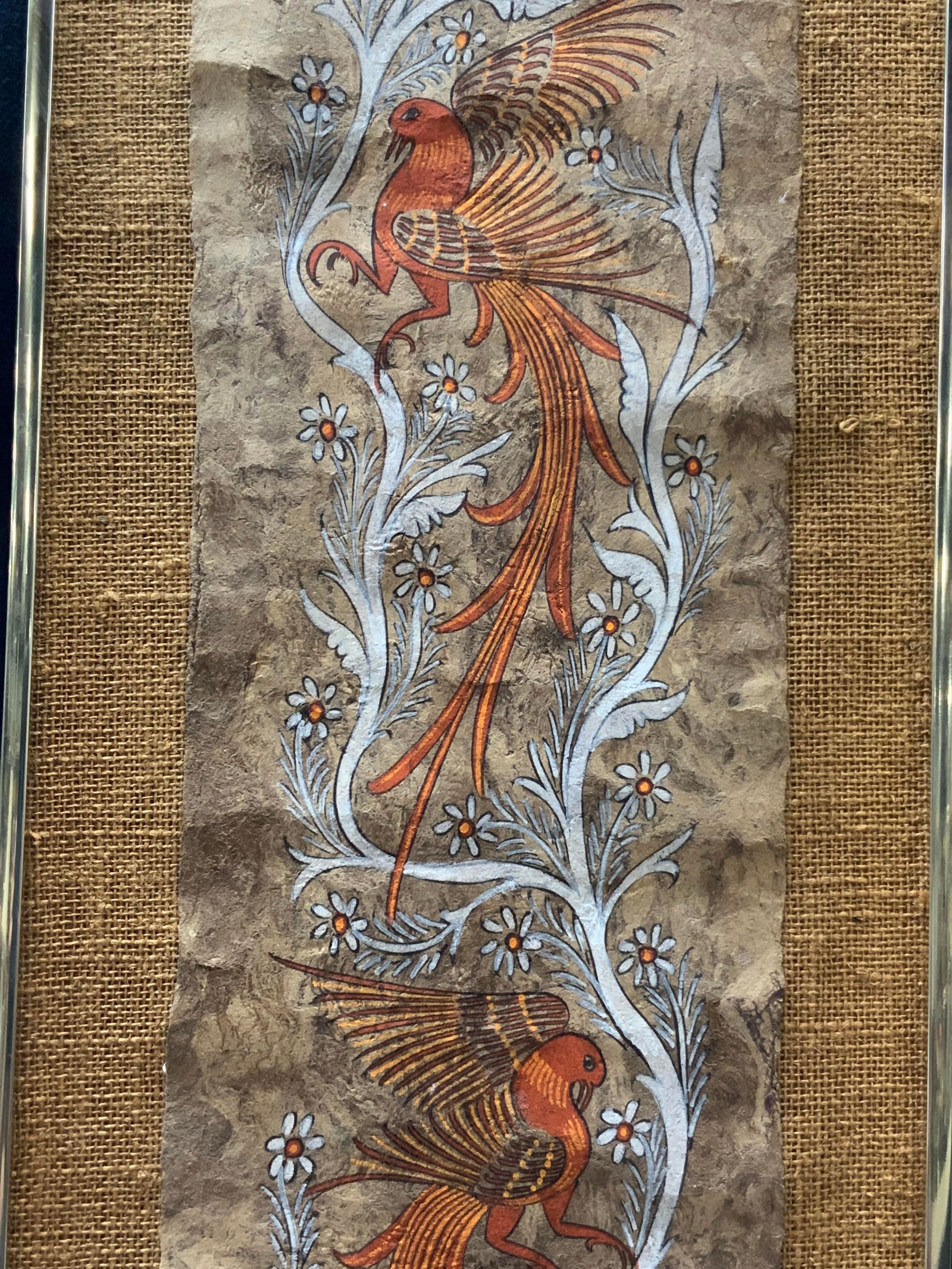 Folk Art Animal Painting On Hand Made Paper: Folk art animals in red, foxes and birds on a white tree painted on top of hand crafted paper. Affixed to woven backing material. Framed in a gold toned metal frame approx 40 x 12 inches window measur
