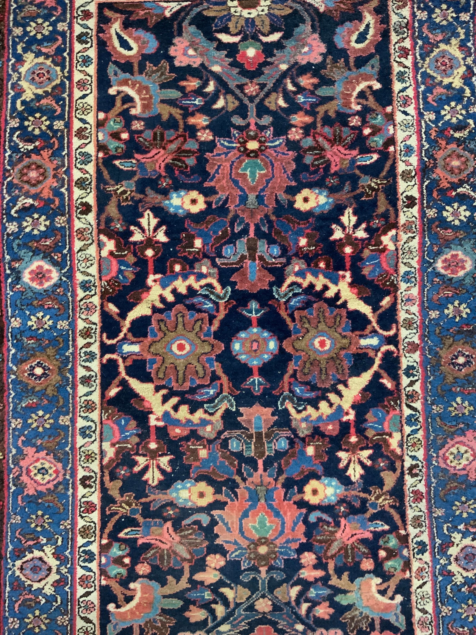 Vintage Handmade Persian Wool Area Rug: Rug is handmade and wool. Piece is vintage possibly antique. Rug is Persian. Piece has intricate multi toned floral motif detail. Rug is room sized. Edges have short cream toned fringes. Rug measures 