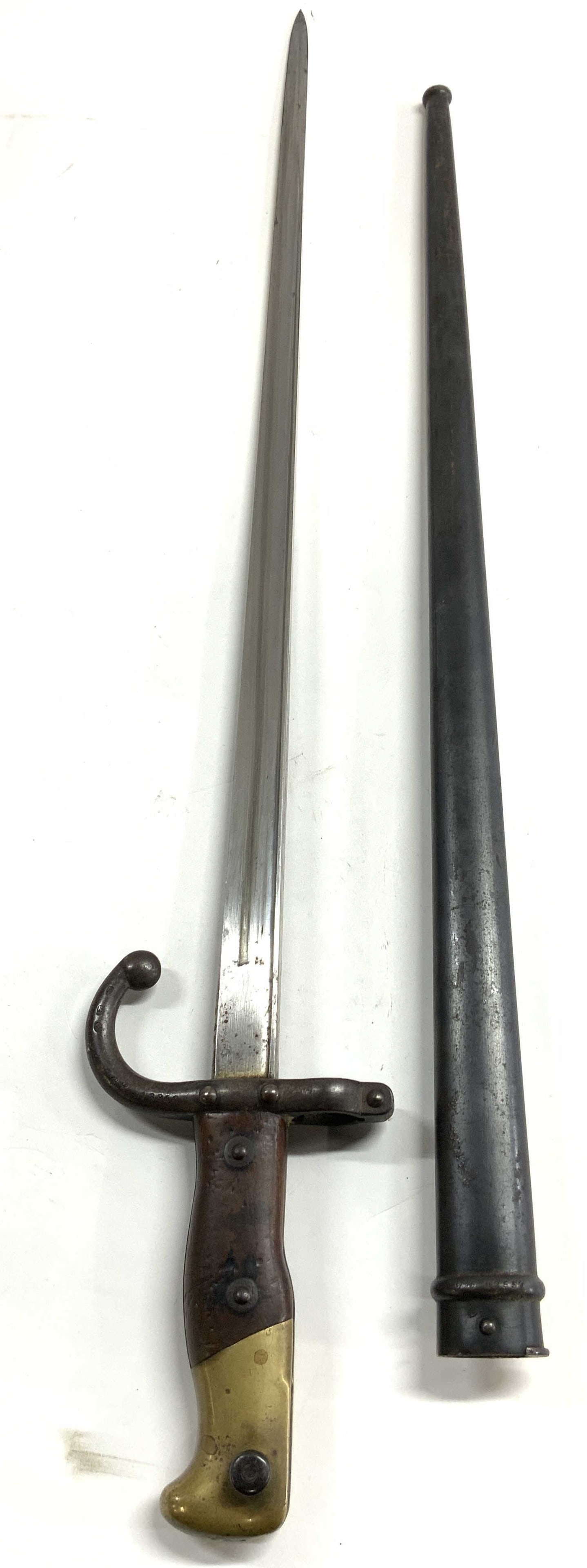 Antique French Bayonet Sword W Scabbard: Appears to be inscribed 1896 (Possible date) scabbard inscribed with script FH & 92557. Antique French bayonet sword. Lot includes sword and scabbard. Piece has wooden & brass handle, metal blade & sc