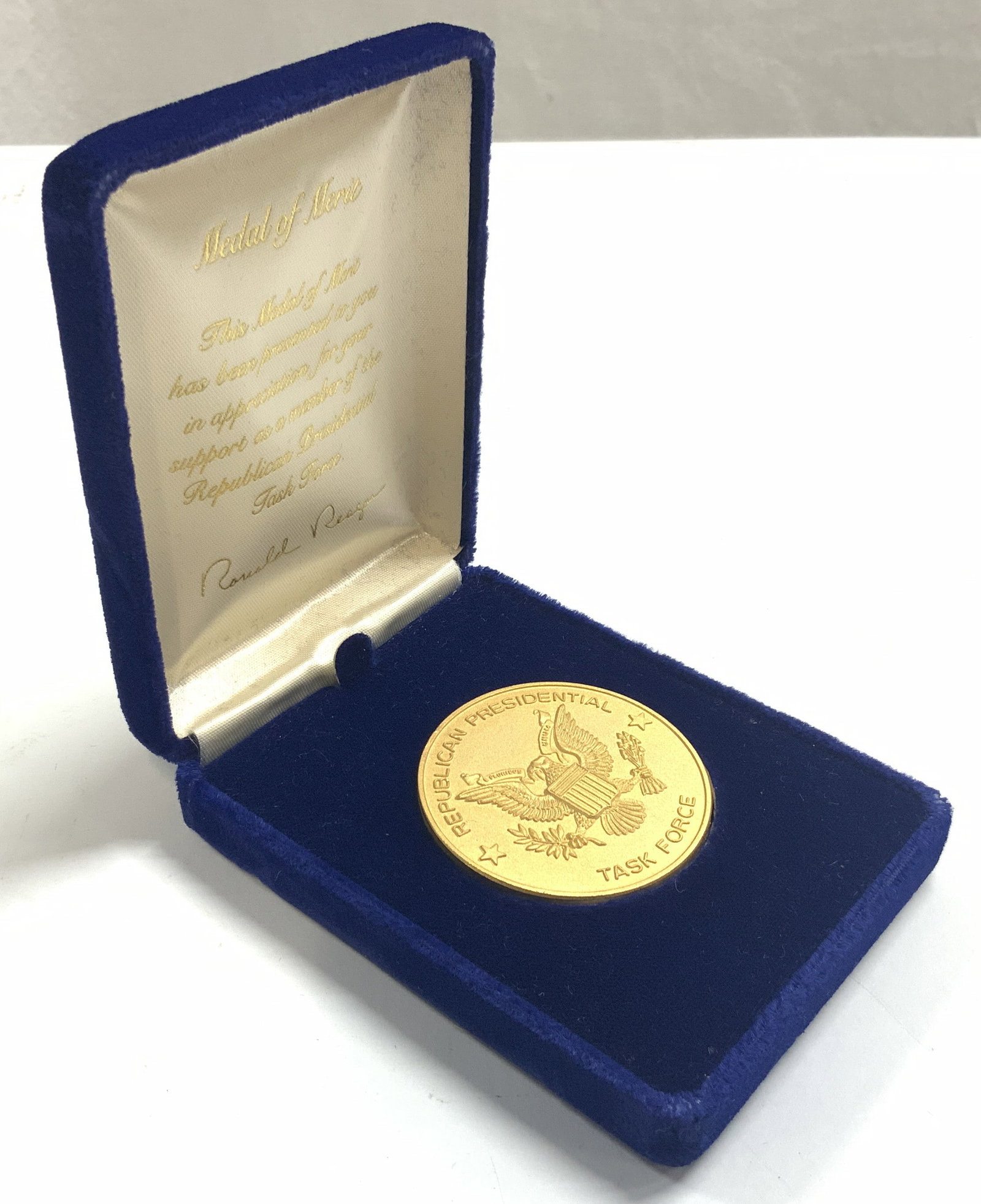 Ronald Reagan Pres Task Force Medal of Merit: Ronald Reagan 1980s vintage Republican Presidential Task Force Medal of Merit. Packaged in the original blue velvet box. Depicts Ronald Reagans signature in gold tone script in the inner lid. Gold-ton