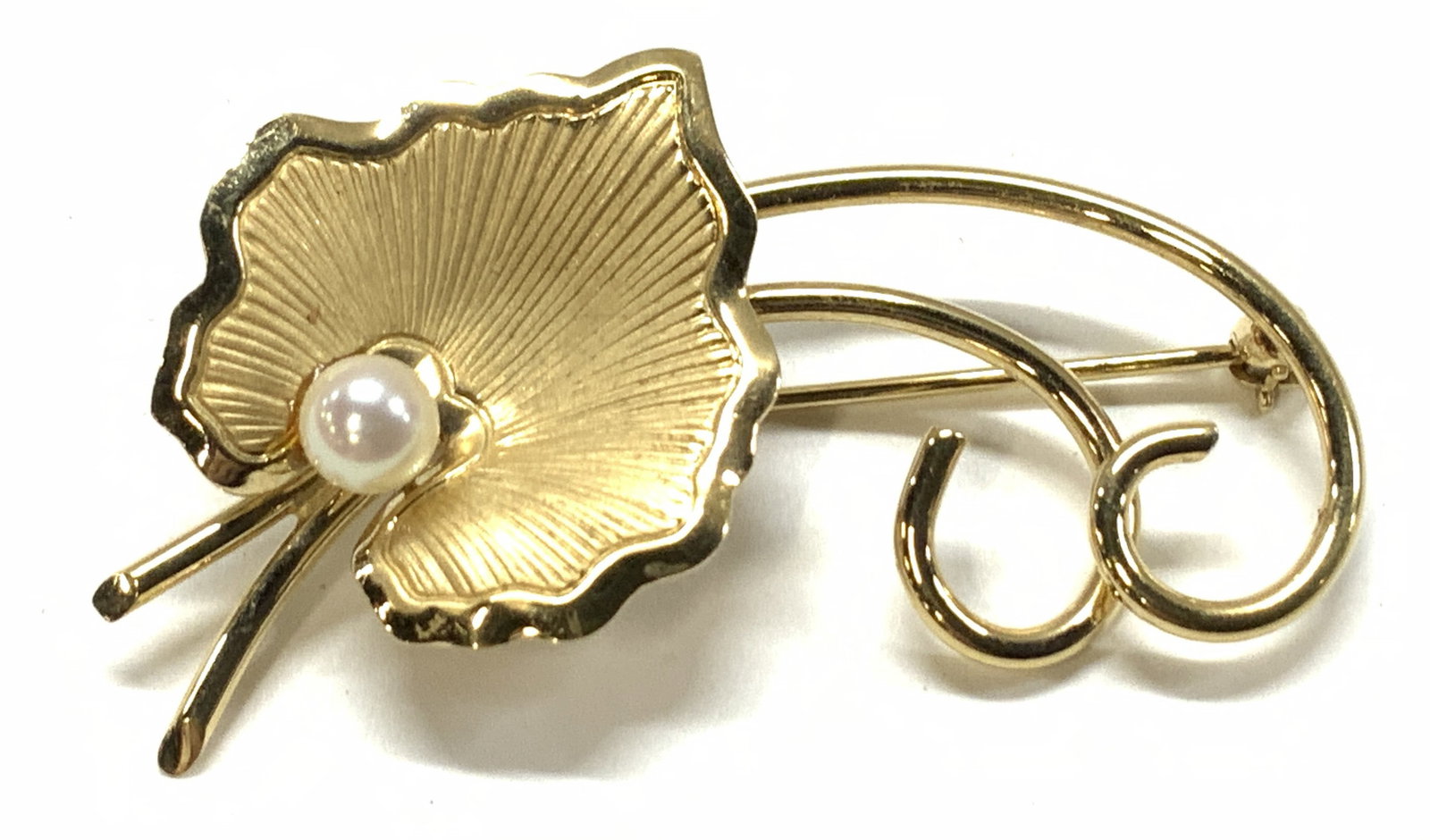 12K Gold Filled Leaf Brooch w Pearl: Hallmarked leaf brooch with a white round Pearl in the center of the leaf. Polished and brushed 12K GF marked 1/20 12K with the manufacturers trademark. Pearl measures 4 mm. Brooch measures approx 2 i