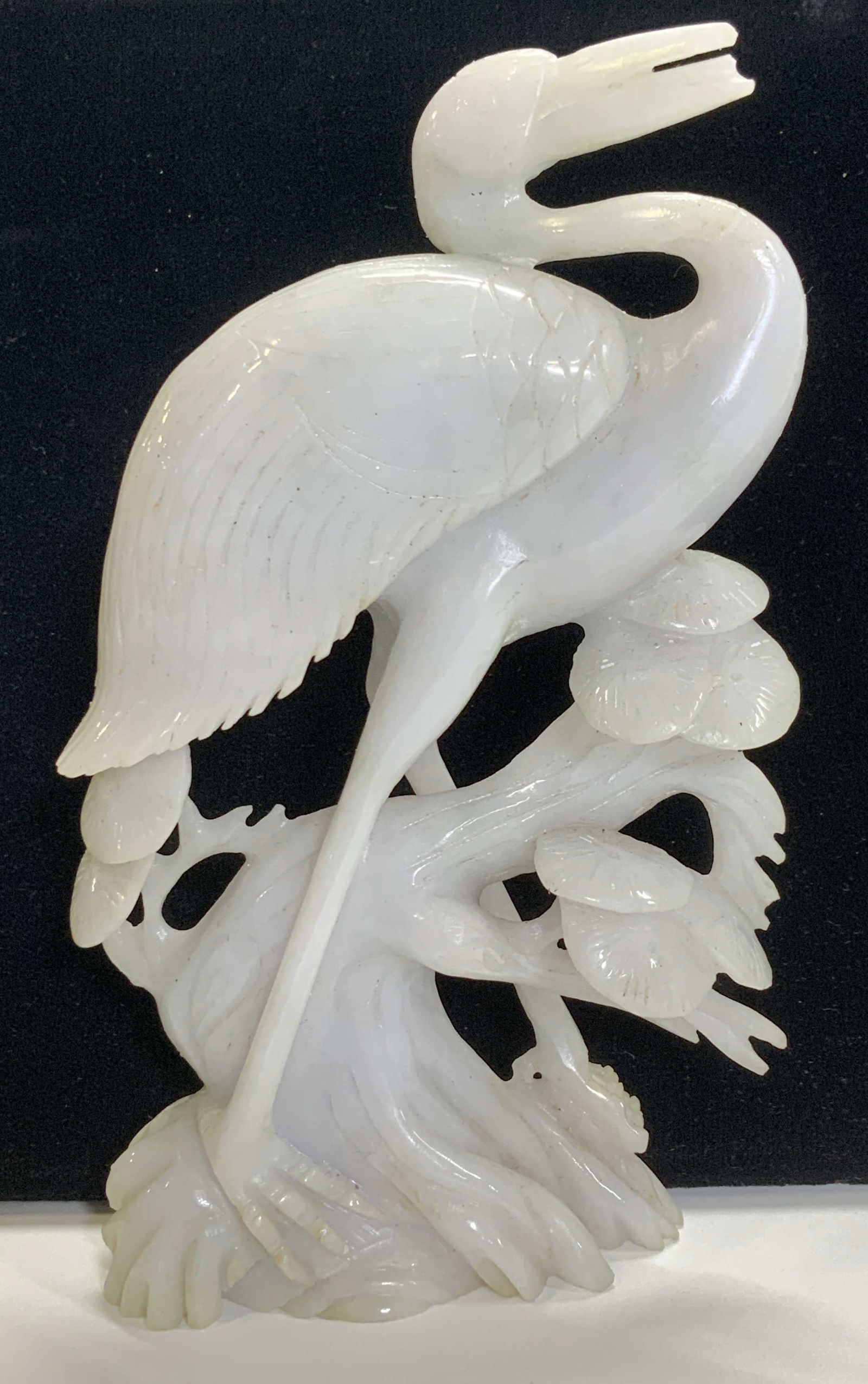 Carved White Jade Crane Figural: Hand carved white jade crane sculpture. Carved from a solid piece of gemstone block. Intricate detail. White with grey tones. Measures 6 x 3.5 in. Ht x W. Tests positive for jade/ jadeite on gem teste