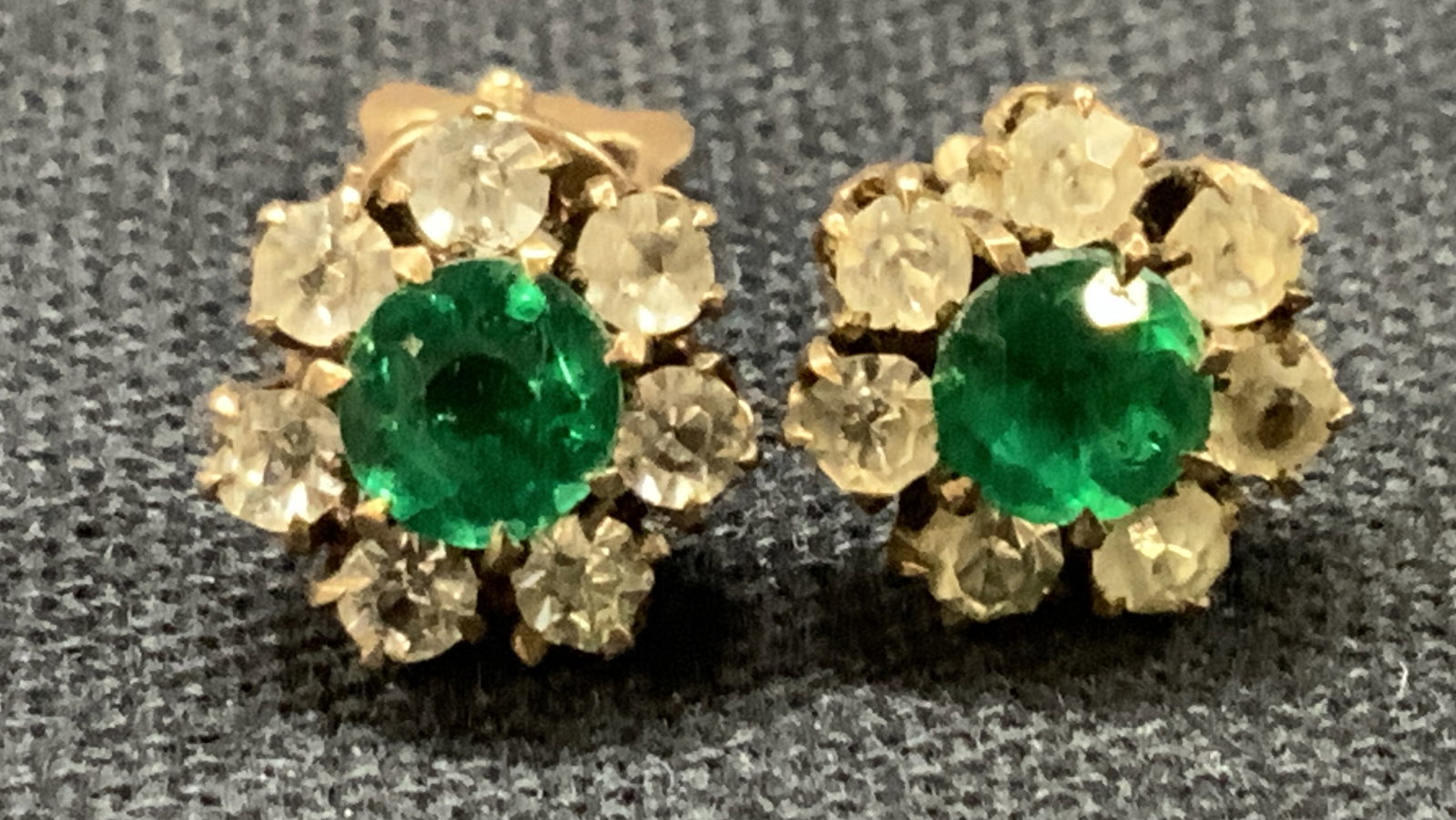 Vntg Gold Tn Jeweled Flower Stud Earrings: Vintage pair of earring in gold toned with screw backings and green and clear faceted crystals in flower shapes, approx 0.5 inches long Evident wearing to gold tones and oxidation to metals. One earri