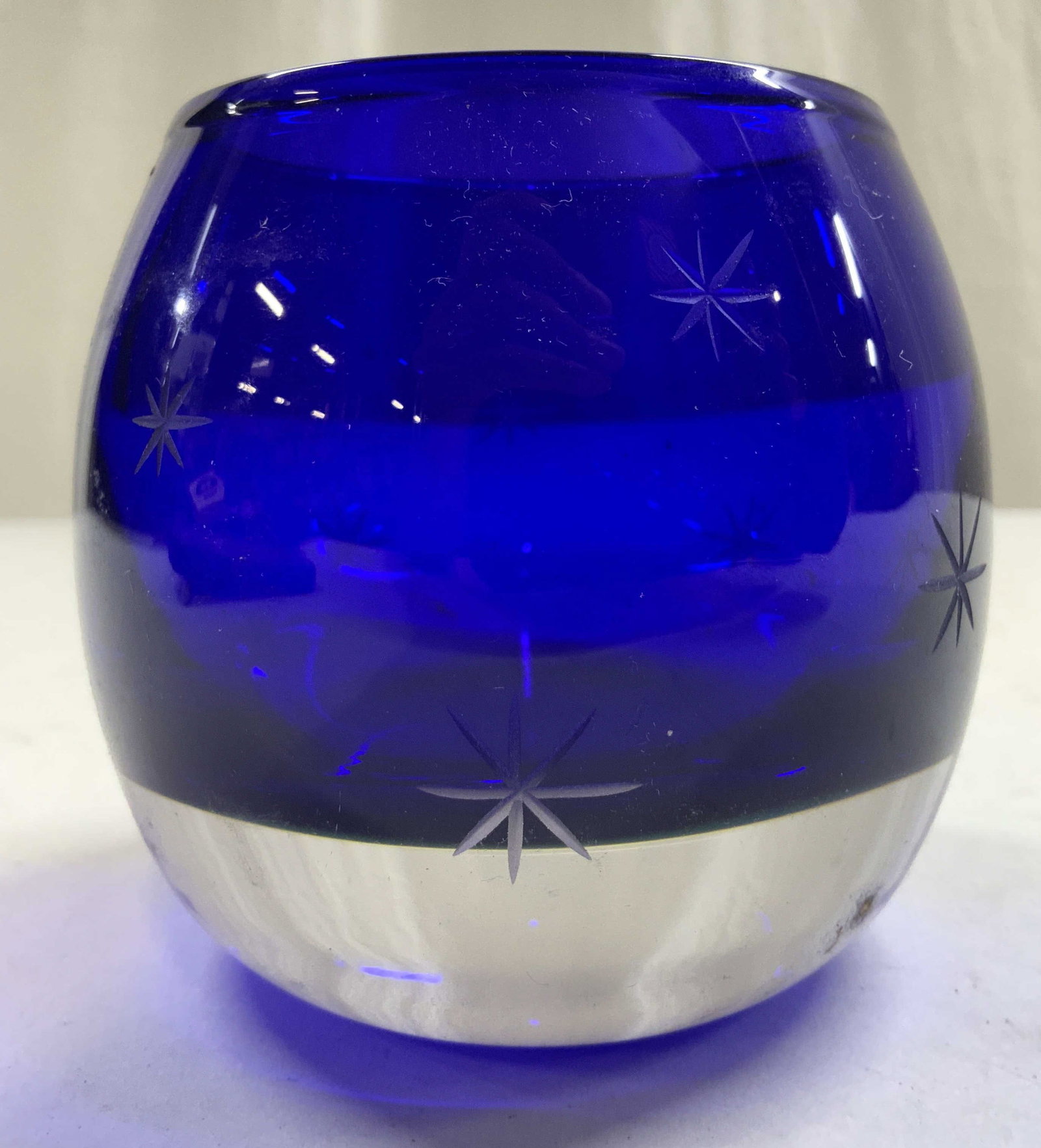 Art Glass Star Sparkle Candle Holder Blue: Candle holder is blue toned with frosted star sparkle detail. Piece is glass tin thick walled base. Vessel measures approximately 3.5 inches tall & wide. Candle holder, art glass, glass candle holder,