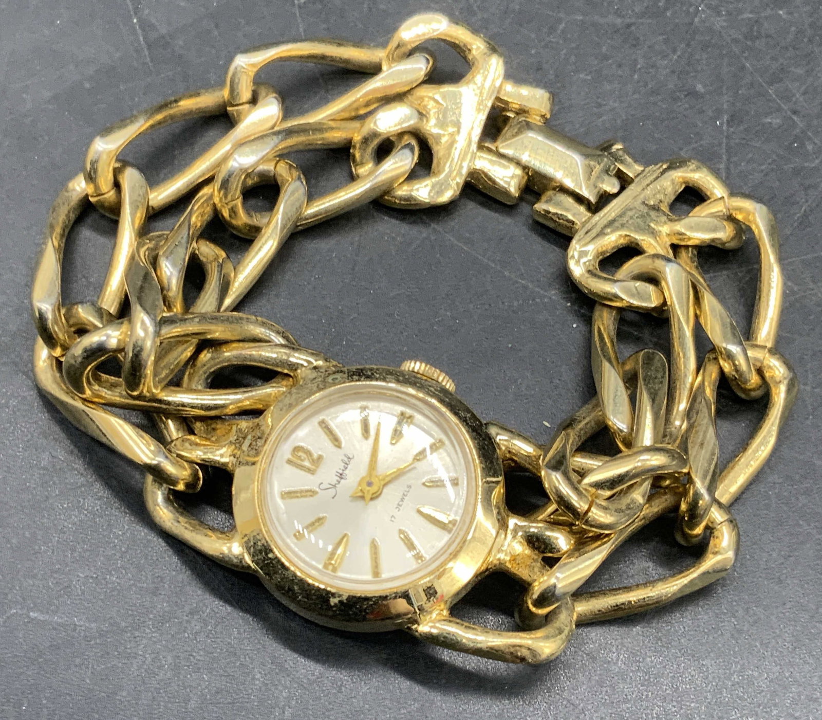 SHEFFIELD 17 Jewels Vntg Gold Tn Metal Wristwatch: A vintage gold tone metal chunky chain wristwatch. The watch face reads SHEFFIELD 17 Jewels. Watch measures approx. 7 inches in length from end to end. Not tested for function. Some surface wear consi