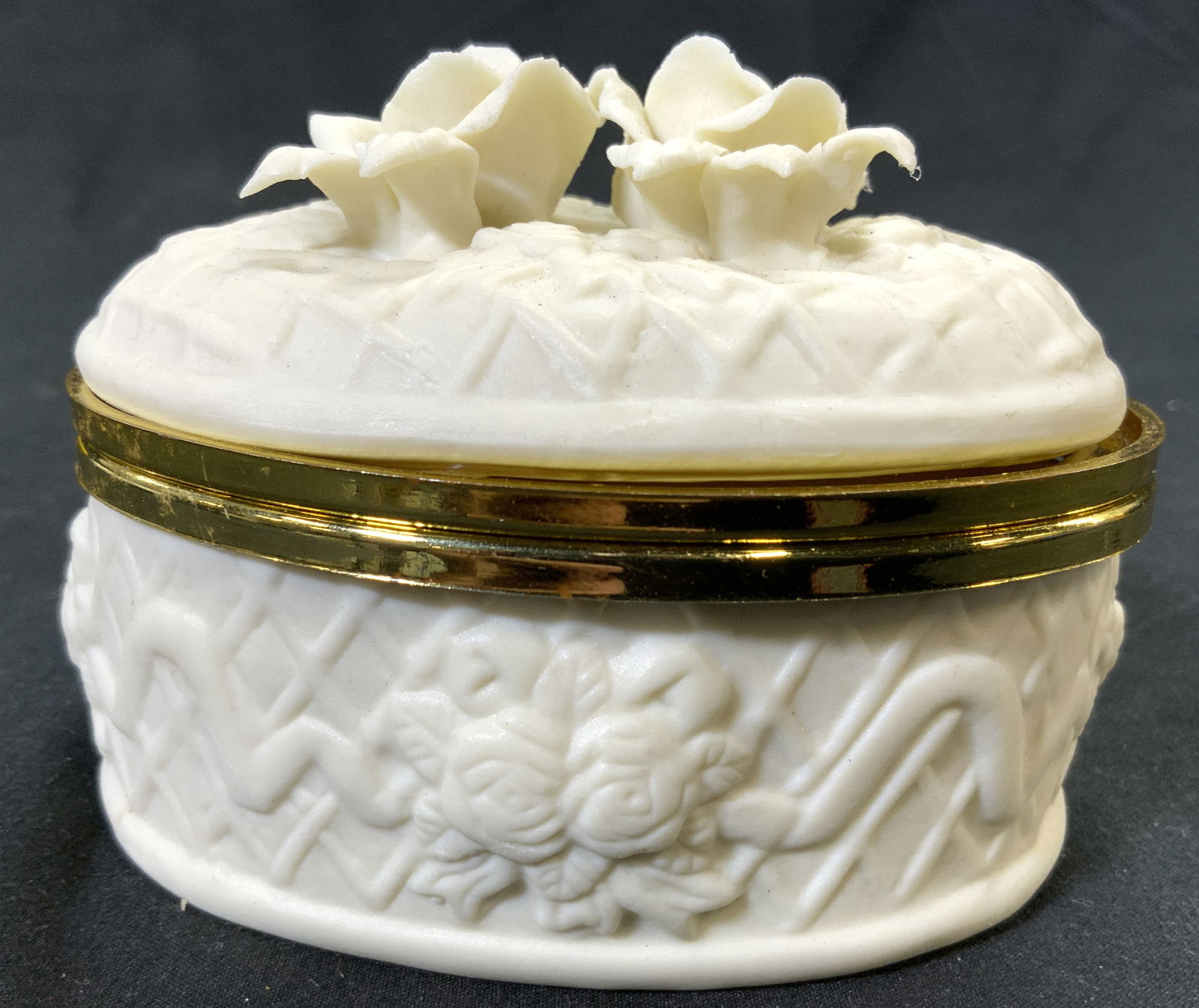Vntg Porcelain Bisque Floral Trinket Box W Lid: Trinket box is bisque Porcelain. Piece is cream toned with floral detail at top. Box has hinged lid. Piece has gilt metal rim. Trinket box measures approximately 4 inches wide 3 inches tall & deep. Tr