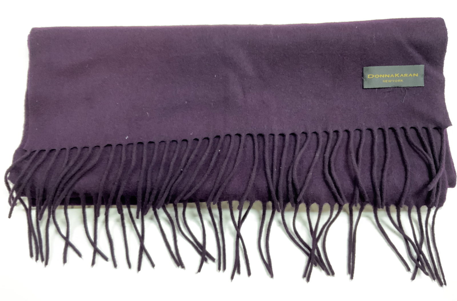 DONNA KARAN Cashmere Scarf W Fringes Purple: Scarf Tag reads DONNA KARAN NEW YORK. Scarf is purple toned. Piece has fringes at edges. Scarf is cashmere. Scarf measures approx. 72 inches long with fringes 19 inches wide. Scarf, Donna Karan scarf,