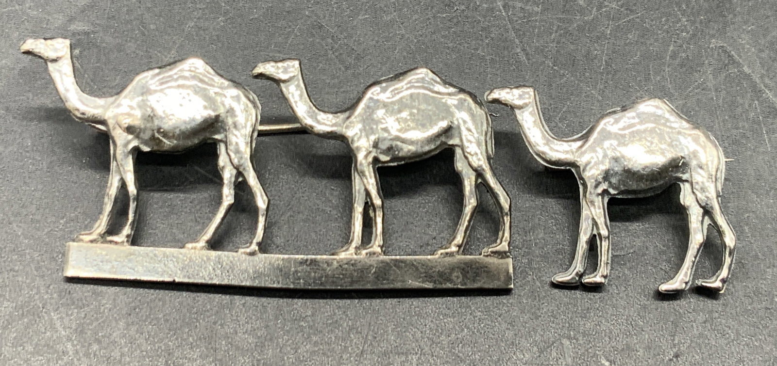 Lot 2 Sterling Silver Camel Pins, Jerusalem: Two sterling silver camel pins. One pin features two camels and the other features a single camel. Larger pin measures approx, 1L x 1.75W in. Undersides marked ST925 Sterling, Jerusalem. Total weight 