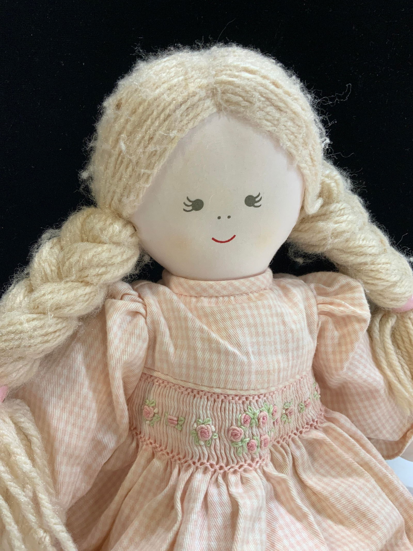 House of Hatten Inc Fabric Cotton Doll: House of Hatten Inc cotton fabric doll. Pink and white flannel dress, some pulling to wool yarn hair. Light discoloration on leg noted and orange spotting on back of dress, consistent with use and exp