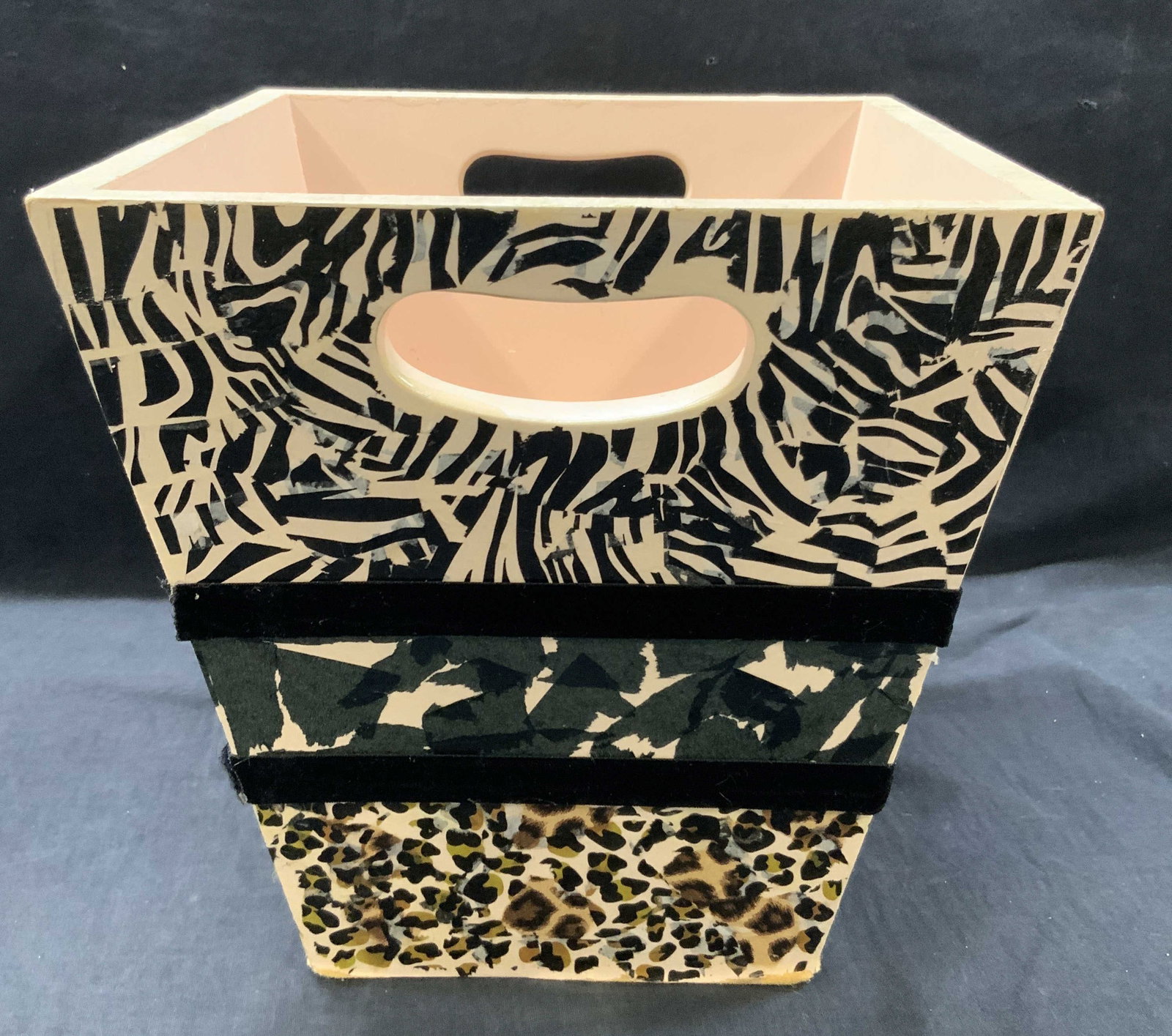 Wooden Collaged Waste Basket: Wooden waste basket with collaged zebra and animal print papers. Approx 10.75 inches tall and 10 inch diameter. Moderate wearing to collage on surface and to wooden edges. Wooden waste basket, wooden