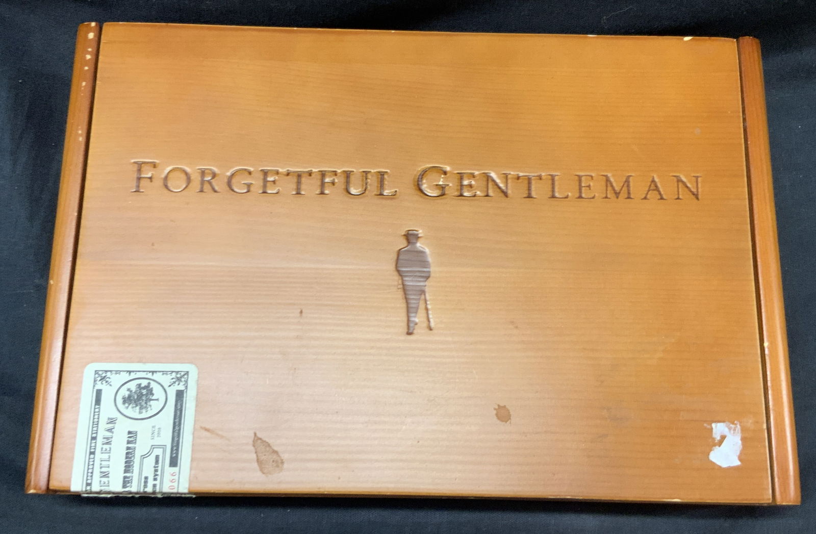Forgetful Gentleman Dresser Box: Orange toned wooden cigar box/ dresser box. Marked The forgetful gentleman, elephant cards. Lined interior with black velvet. Approx 10 x 7 x 2 inches. Moderate surface wearing to wood and to interior