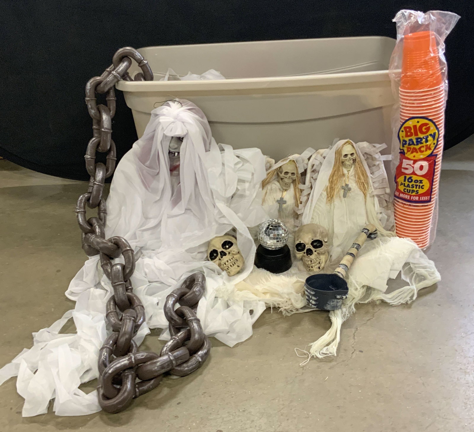 Group Lot Halloween Decorations: A group lot of Halloween decorations. Lot includes High Skeleton Angels, packaged orange cups, skulls, CDs, and more. High Skeleton Angel measures approx. 18L x 7.5W in. Items in the group lot are cra