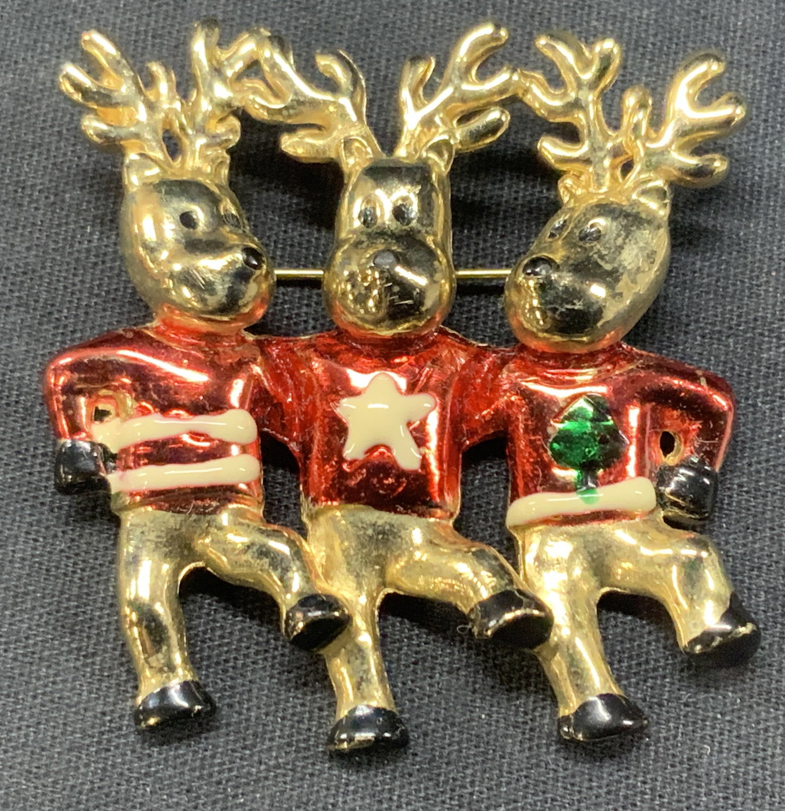 Gold Tn Dancing Reindeer Brooch: Gold toned reindeer brooch with three reindeer dancing and wearing holiday sweaters. Approx 2 x 2 inches Minor wearing to jewelry due to age and use. Reindeer decor, holiday brooch, brooch, ladies bro