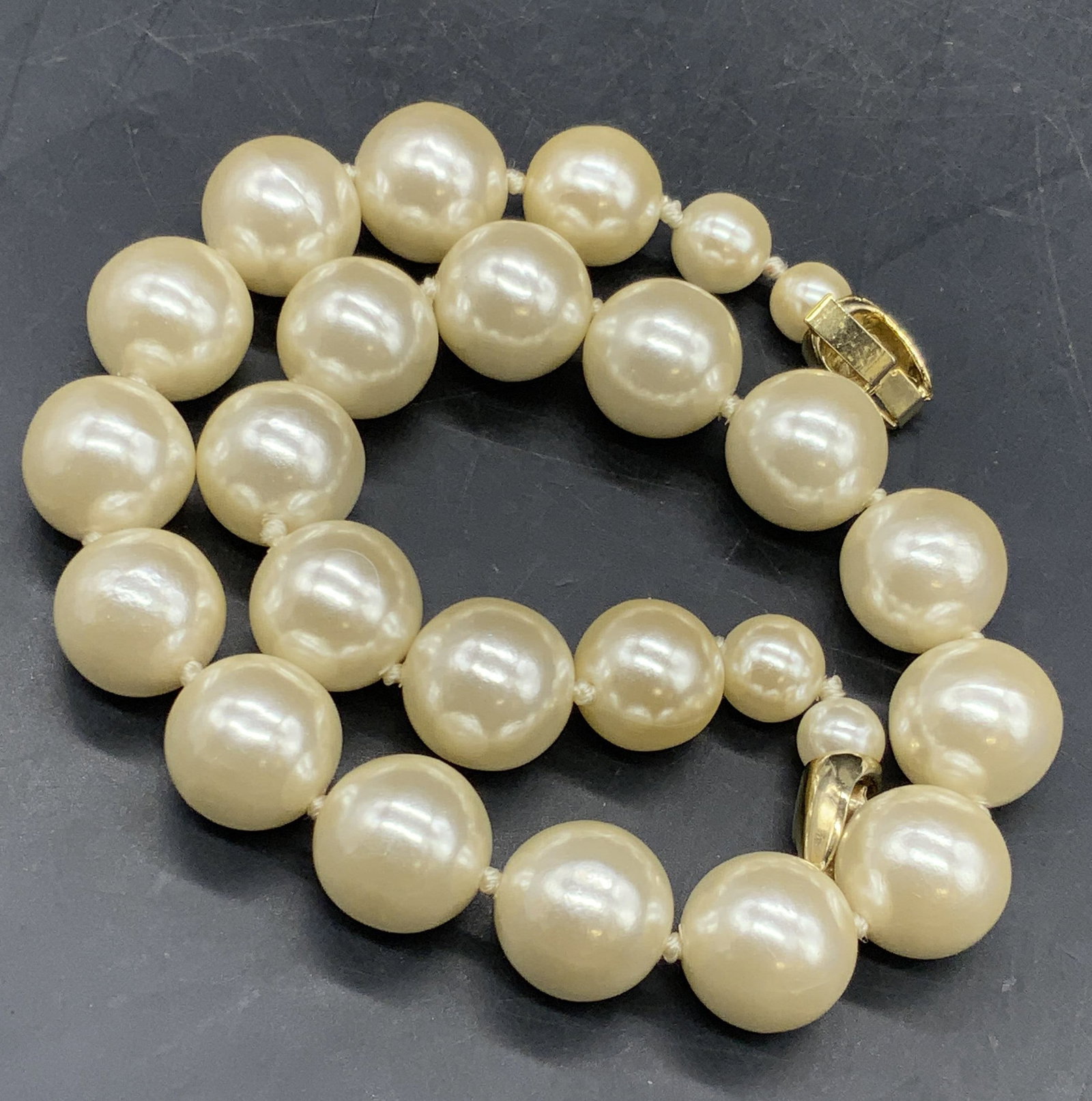 Pearlescent Beaded Choker Necklace, Jewelry: A pearlescent beaded necklace that secures with a gold tone metal box clasp closure. Some variety to the bead sizing. Beads are crafted from composite material. Measures approx. 16 inches in length. M