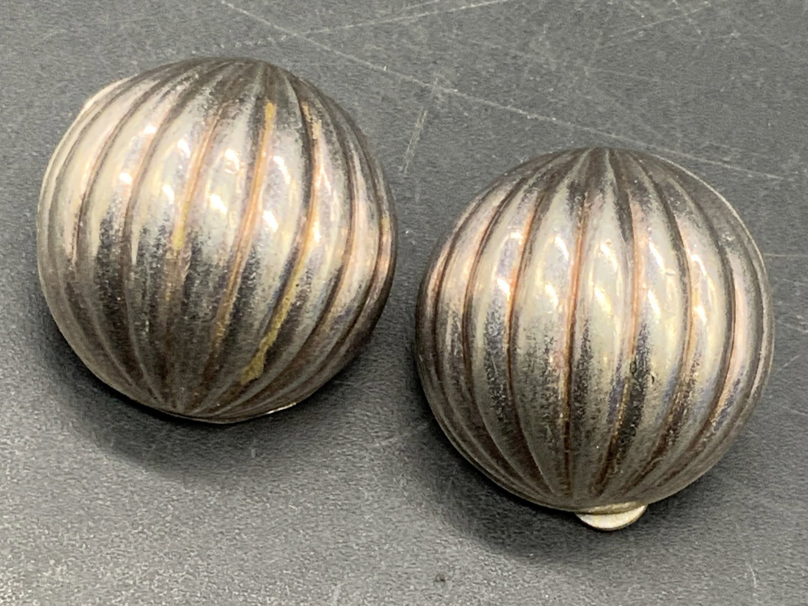 Vintage Sterling Silver Clip On Earrings, Italy: Vintage sterling silver clip on earrings. Circular form with a ribbed design. Marked W, 925, Italy. Measures approx. .75W x .75L in. Some surface wear and discoloration present. Total weight .31 ozt. 