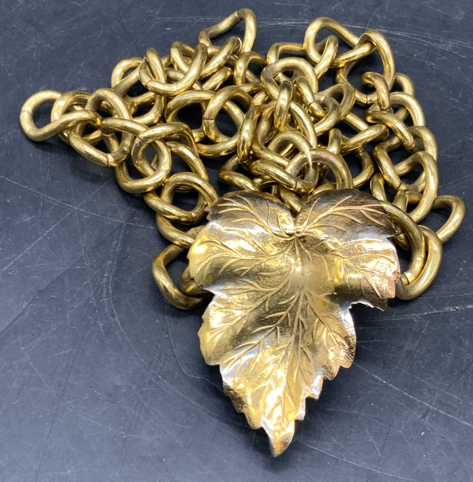 Vintage Leaf Motif Chain Belt: A vintage gold tone metal chain belt featuring a leaf form clasp. Length measured end to end approx. 33 inches. Some discoloration and surface wear present. Collectibles, vintage accessories, vintage 