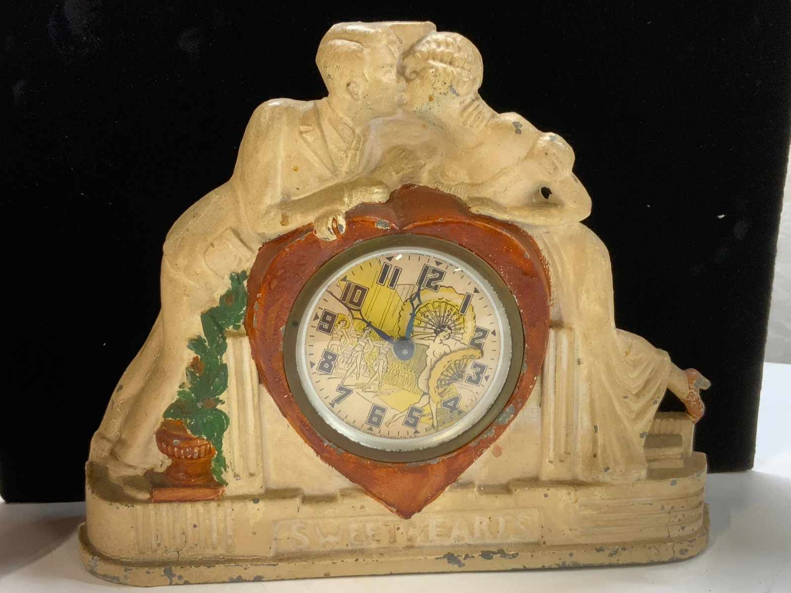Vntg UnitedClockCorp Sweethearts Toleware Clock NY: United Clock corporation based in Brooklyn , NY. Painted metal mantle clock, dated 1934? made in USA. Clock it titled Sweethearts . Interior of clock is a paper lithograph of dancing club beauties, on