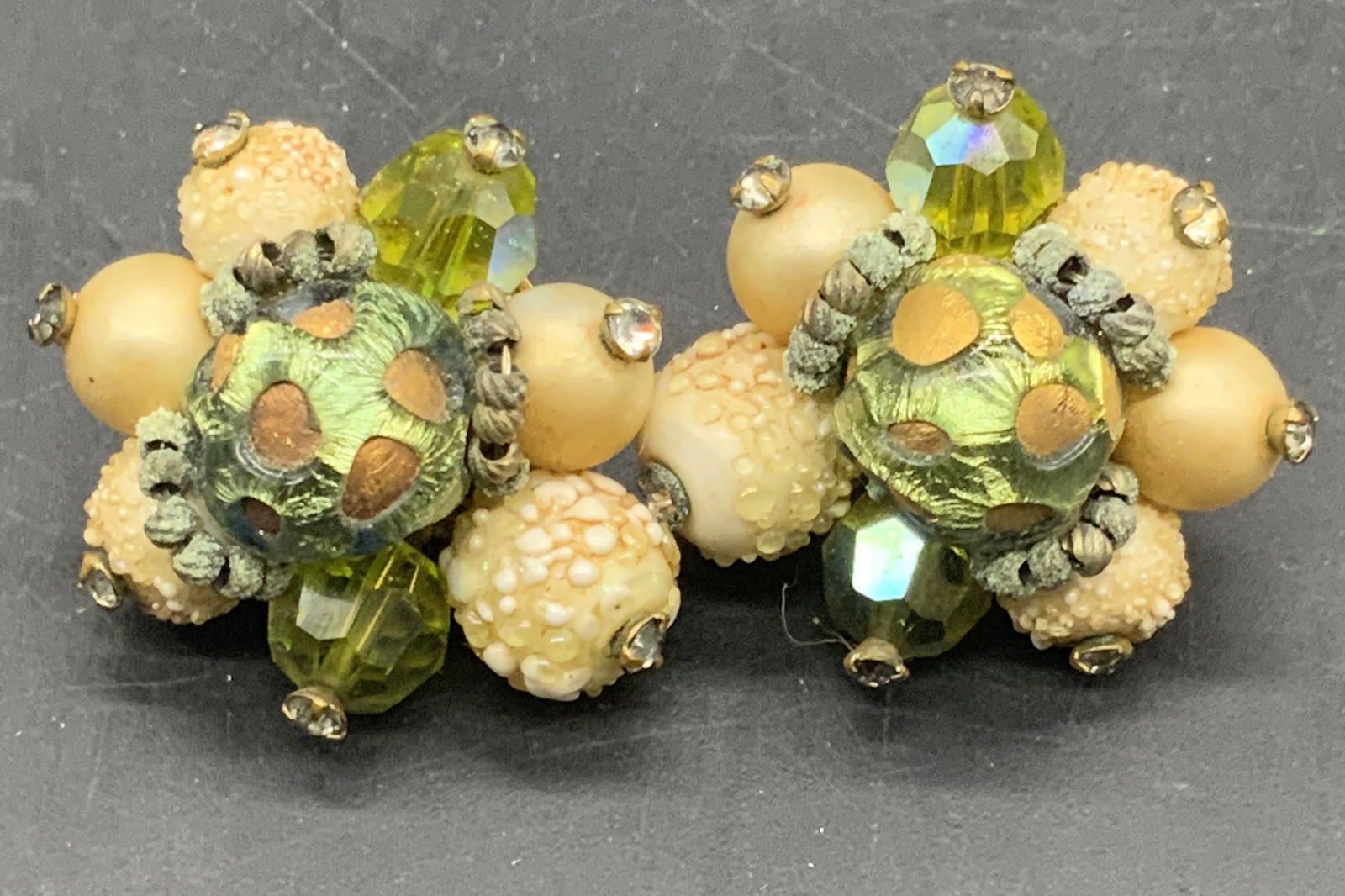 VENDOME Vintage Bejeweled Cluster Clip On Earrings: Vintage bejeweled cluster clip on earrings marked VENDOME PAT 28095 to the reverse. Crystal and composite beads to the cluster. Metal backing. Earrings measure approx. 1.25L x 1W in. Wear consistent w