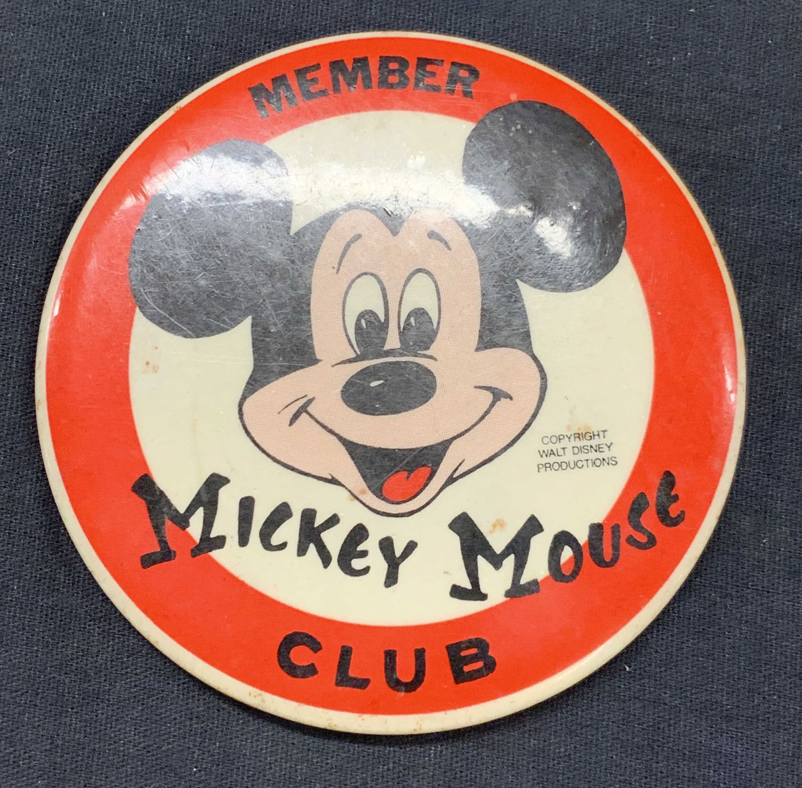 Vntg Disney Mickey Mouse Club Member Pin: Vintage red and white 3.5 inch wide Mickey Mouse club member pin. With Mickey Mouses head in the center, copyright Walt Disney corporation. Moderate discoloration and wearing to pin due to age and use