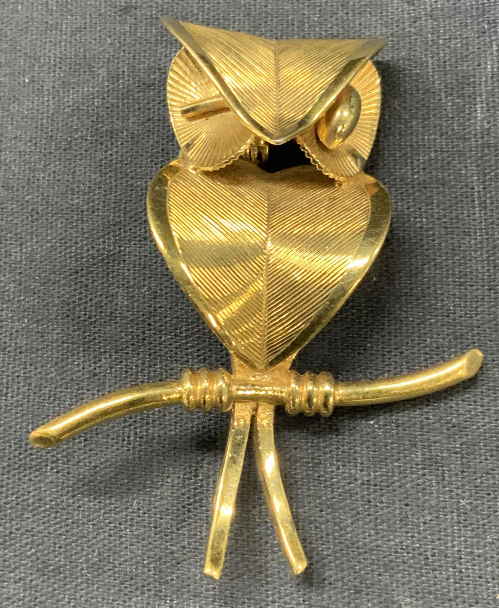 Coro Craft Gold Tn Owl Brooch: Marked Coro craft. Gold toned metal brooch in the shape of an owl with etched grooves on face and body of brooch, approx 2.25 inches long and 2 inches wide Minor wearing to surface, scratches observed