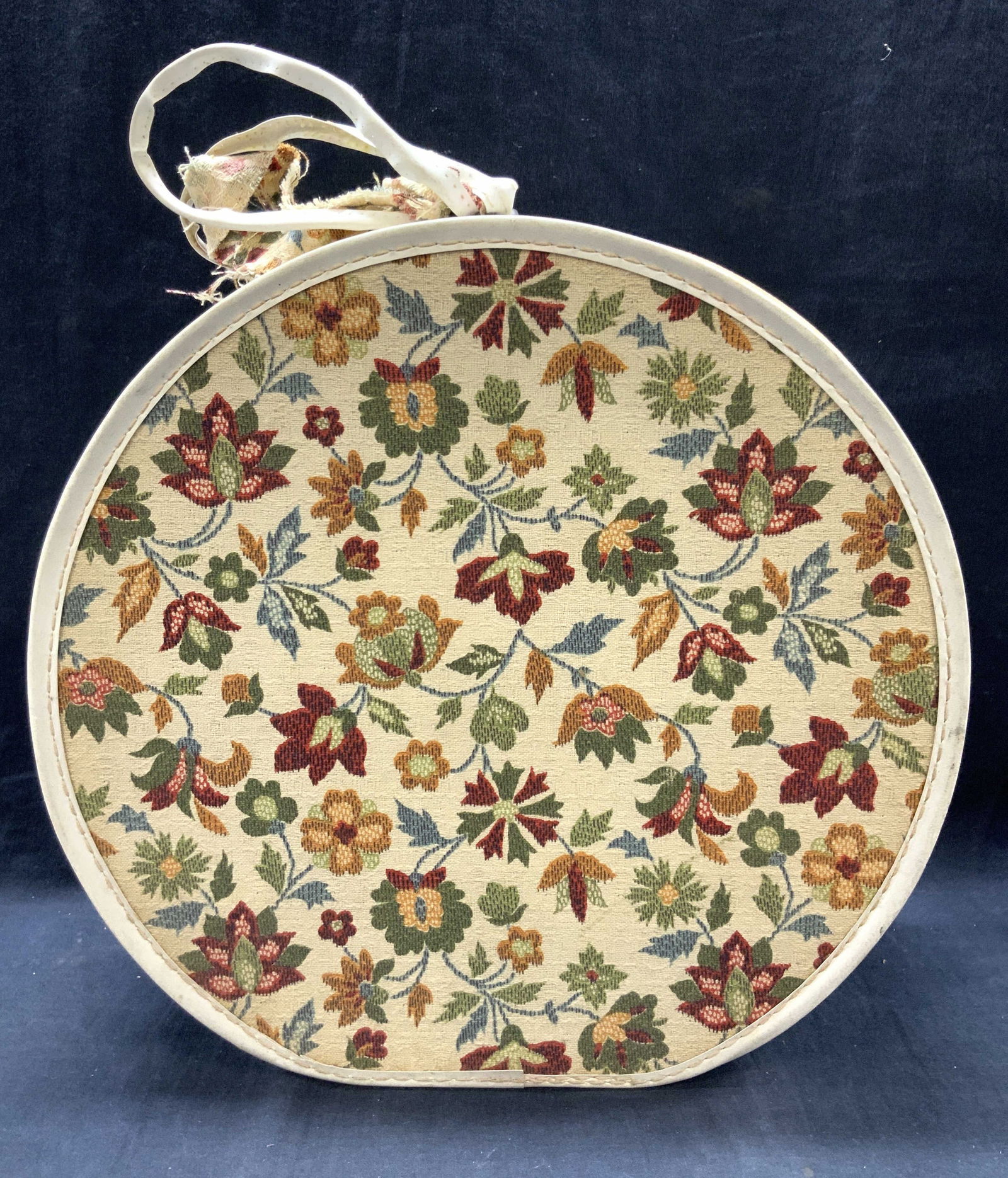 Vntg Embroidered Leather Hat Box: White toned leather style hat box with embroidered floral designs on both sides of the box. Zipper lid and side handle. Approx 13 x 14 inches and 5 inches thick. Moderate discoloration to leather and