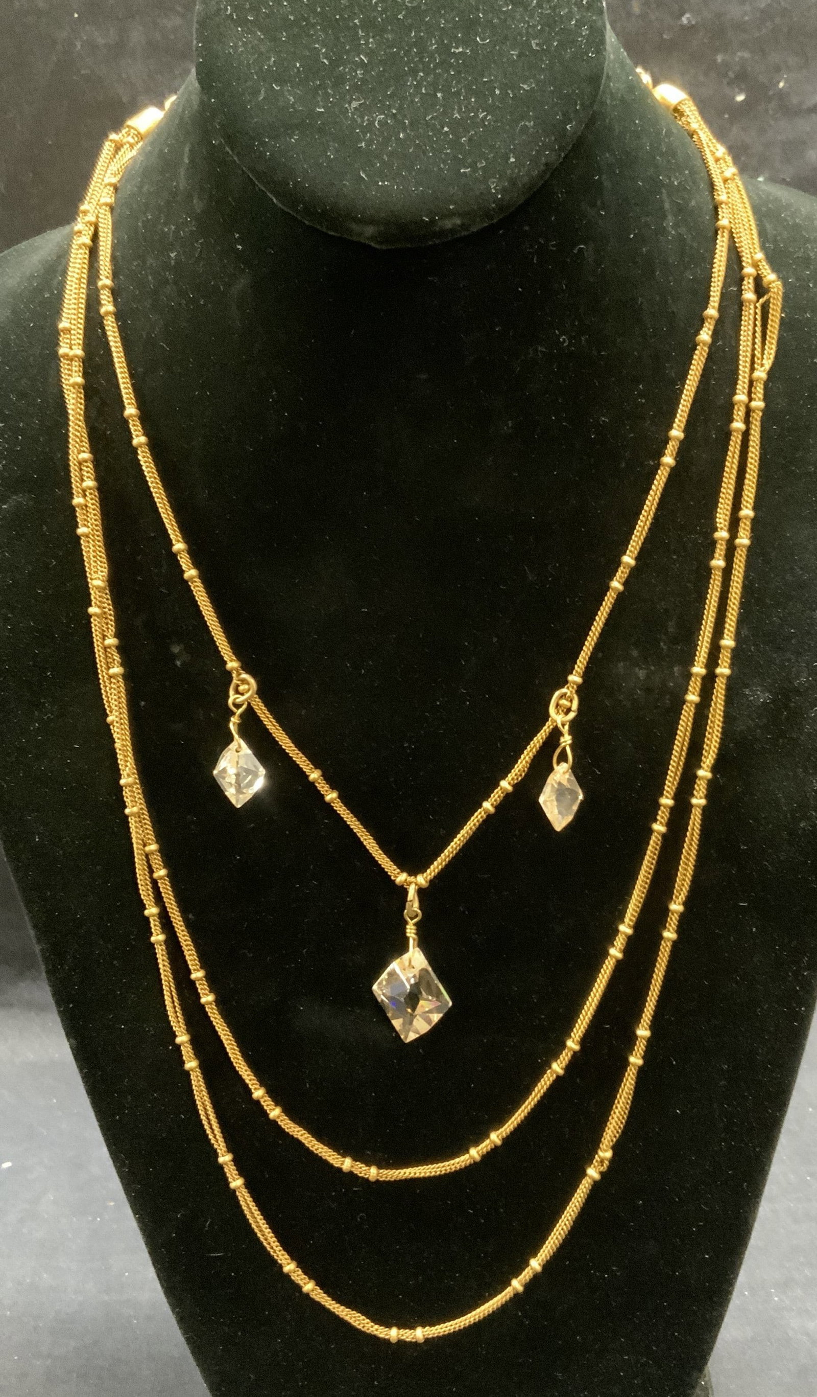 Chicos Gold Tone Crystal Multi Strand Necklace: Chicos gold tone multi strand necklace with colorless crystal beads. Signed on hang tag. Drop length approx. 9 inches. Includes jewelry pouch. Some surface wear including scratching observed. Estate j