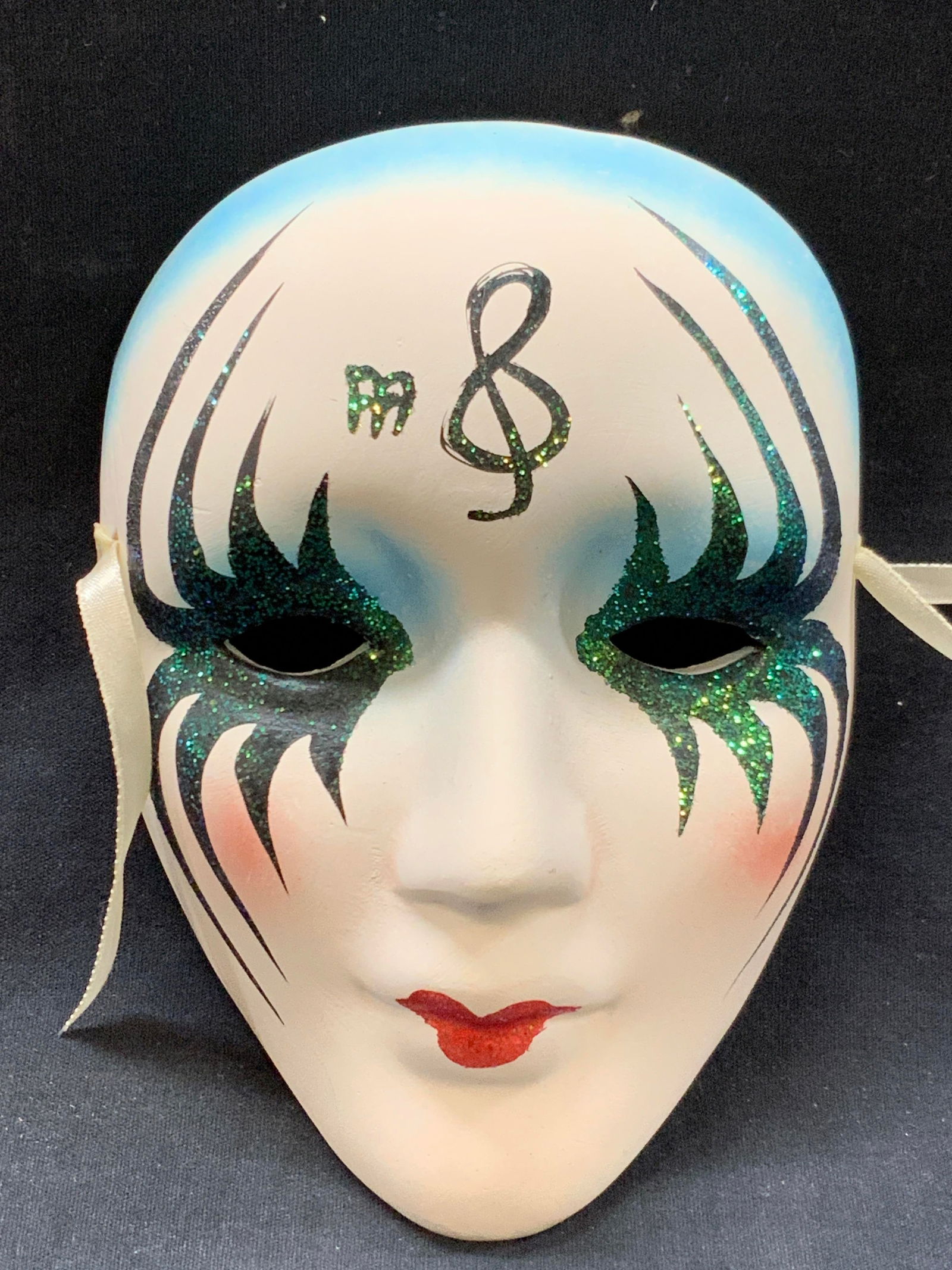 Hand Painted Ceramic Opera Mask: Hand painted ceramic/ plaster crafted opera mask of a womans face with makeup made of glitter with music notes painted on the forehead. Approx 7 x 5 inches Minor wearing to ceramic due to age and use