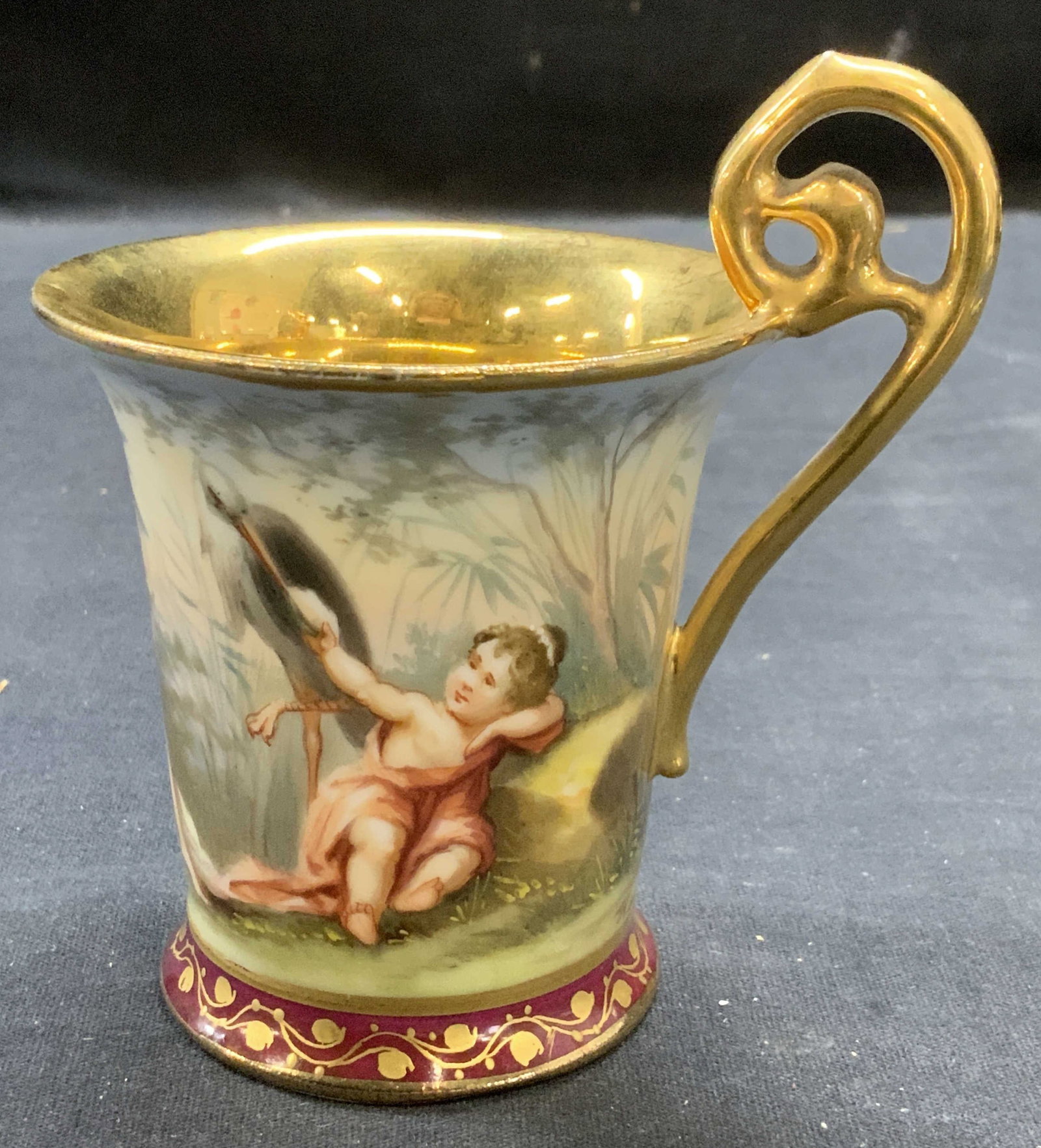 Vintage Signed Gilt Porcelain Figural Cup: Vintage signed gilt porcelain cup with hand painted Figural motif. Signed to underside, partially legible reads Herbert. Measures approx. 3 x 4 inches. Some surface wear including scratching observed.