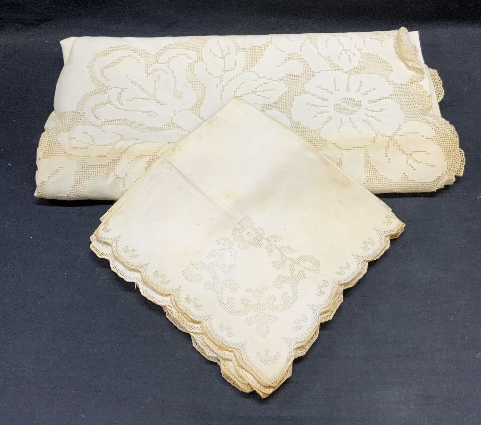 Lot 7 White Cotton Lace Napkins & Tablecloth: Set of 6 white cotton napkins with lace edge and decoration. Measure approx. 17 x 16 inches. White cotton tablecloth with lace due and decoration. Measures approx. 65 x 65 inches. All pieces have wear