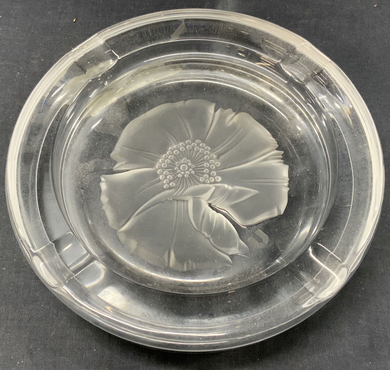 Emanuel Ungaro Crystal Orchid Ashtray, Japan: Marked on underside U by Emanuela Ungaro by Sasaki Crystal Japan Clear crystal with pressed image of an orchid in frosted glass in center. Approx 8 inches diameter Evident cracking to underside and ov