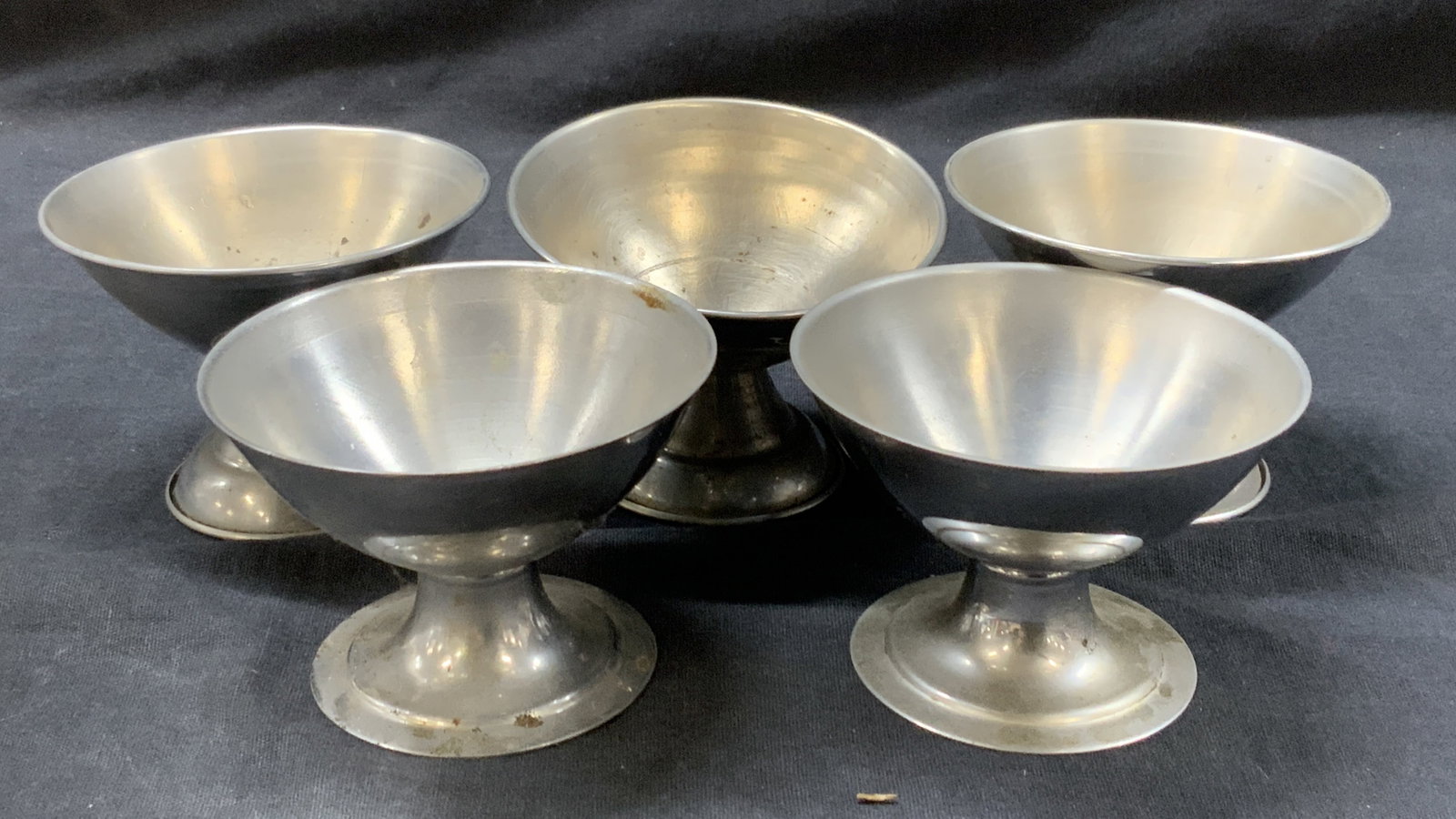 Lot 5 Footed Metal Desert Dish Bases: Lot of White Metal and stainless steel hollow footed dish bases with no dishes. Approx 2.5 and 2 inches tall and 3 inch diameter. Evident wearing and discoloration due to age and use Stainless steel f