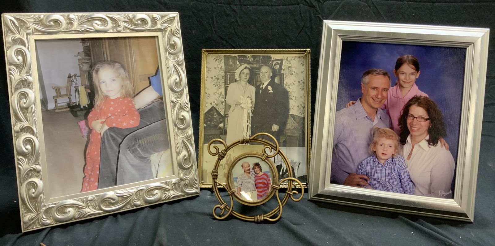 Lot 4 Assorted Picture Frames: Lot includes 1 circular metal picture frame with curled detail, 1 gilt metal picture frame, & 2 silver toned picture frames, (1 with beveled leaf and curl detail. Largest frame measures approximately