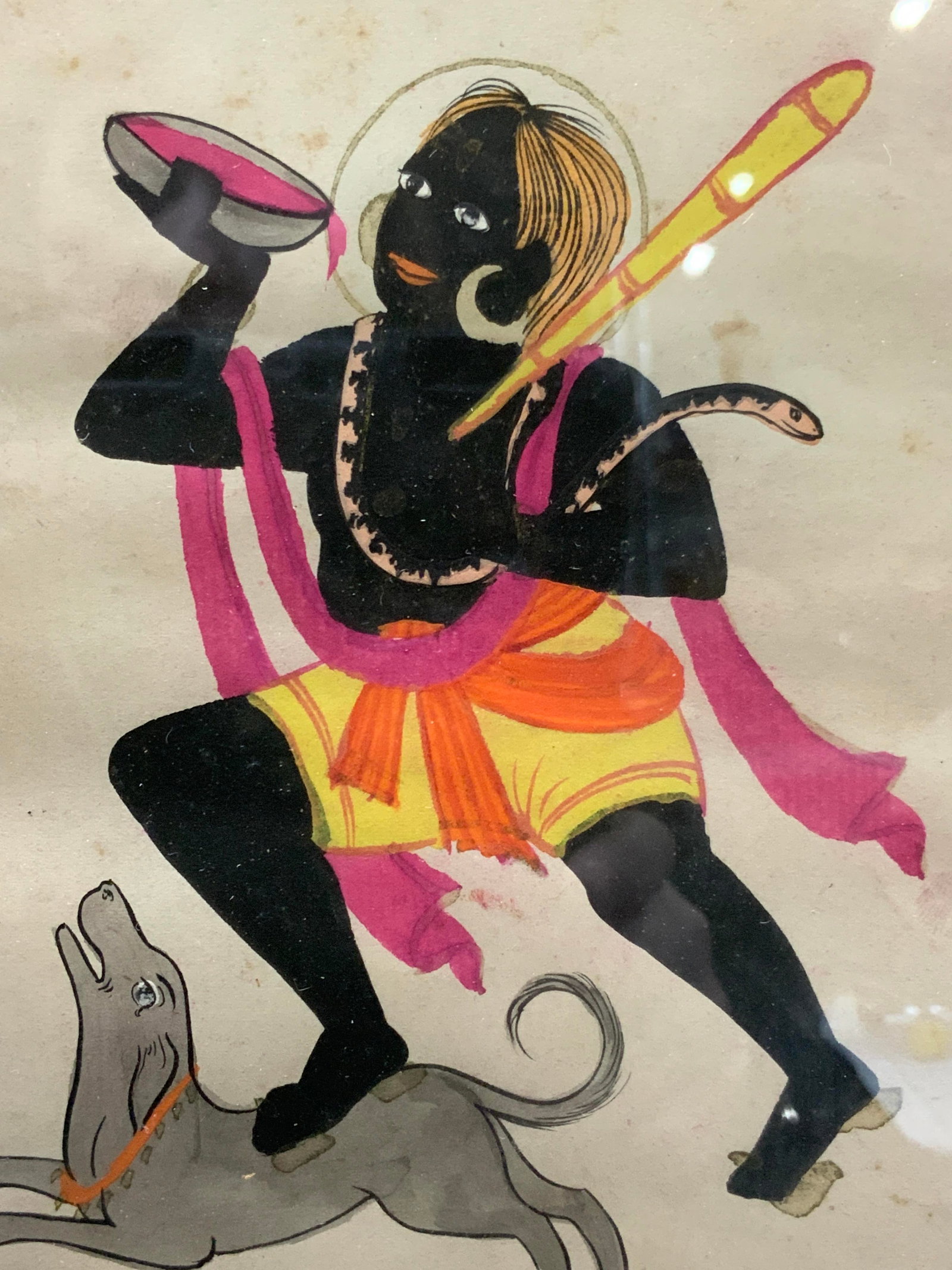 Hand Painted Shiva Hindu Folk Art: Hand painted folk art image of Lord Shiva the destroyer, depicted with a mallet and a snake around his torso, he holds a cup of blood and stands on the back of a dog. Framed in a gold leafed wooden fr