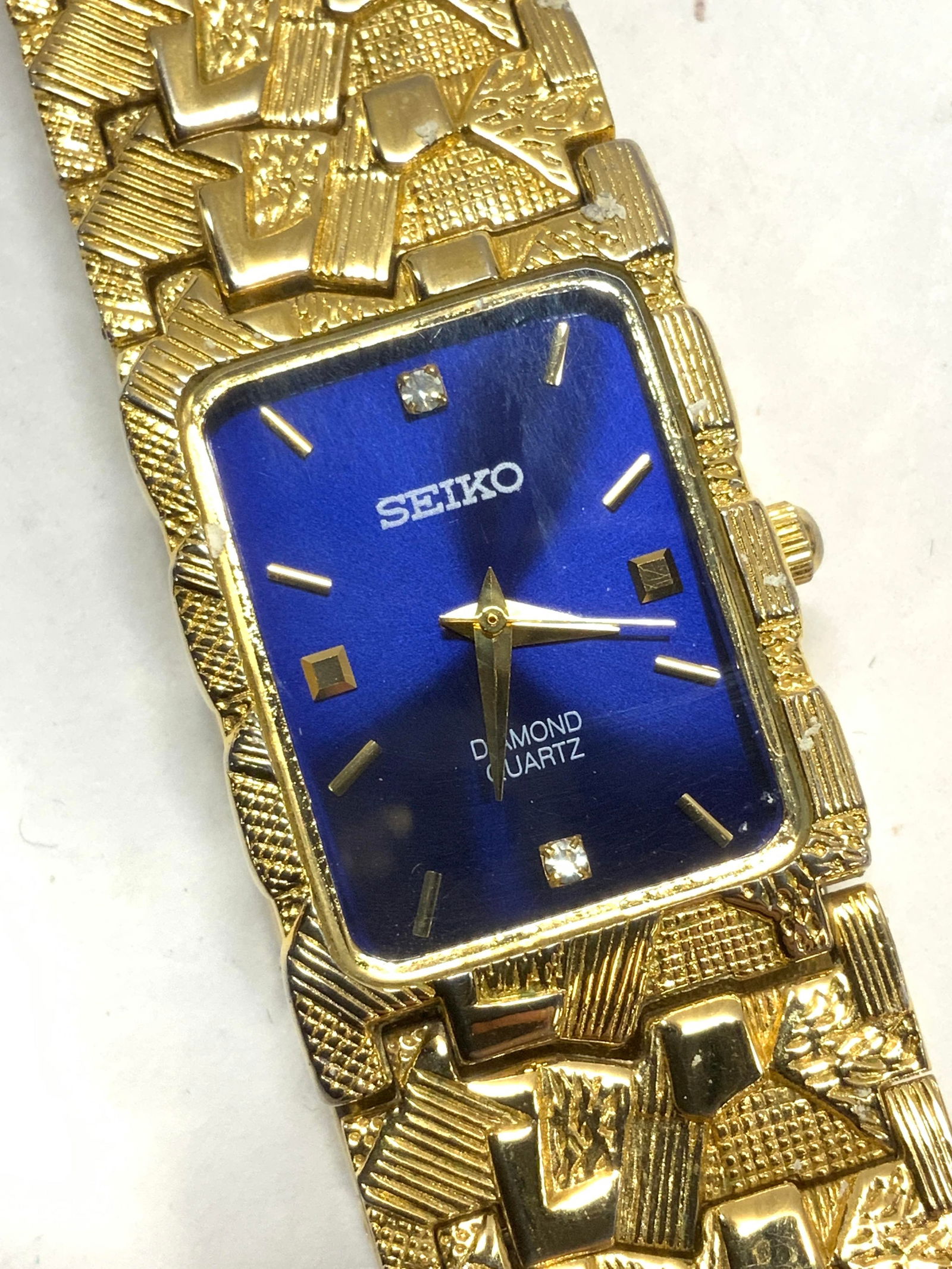 SEIKO 22K Gold Plated Water Resist Watch w Diamond: 22k gold plated SEIKO watch, water resistant , Quartz movement , cobalt blue enamel watch face background with 2 diamonds. 1 in wide , 8.5 in. Long, links can be removed by a jeweler. Watch case measu