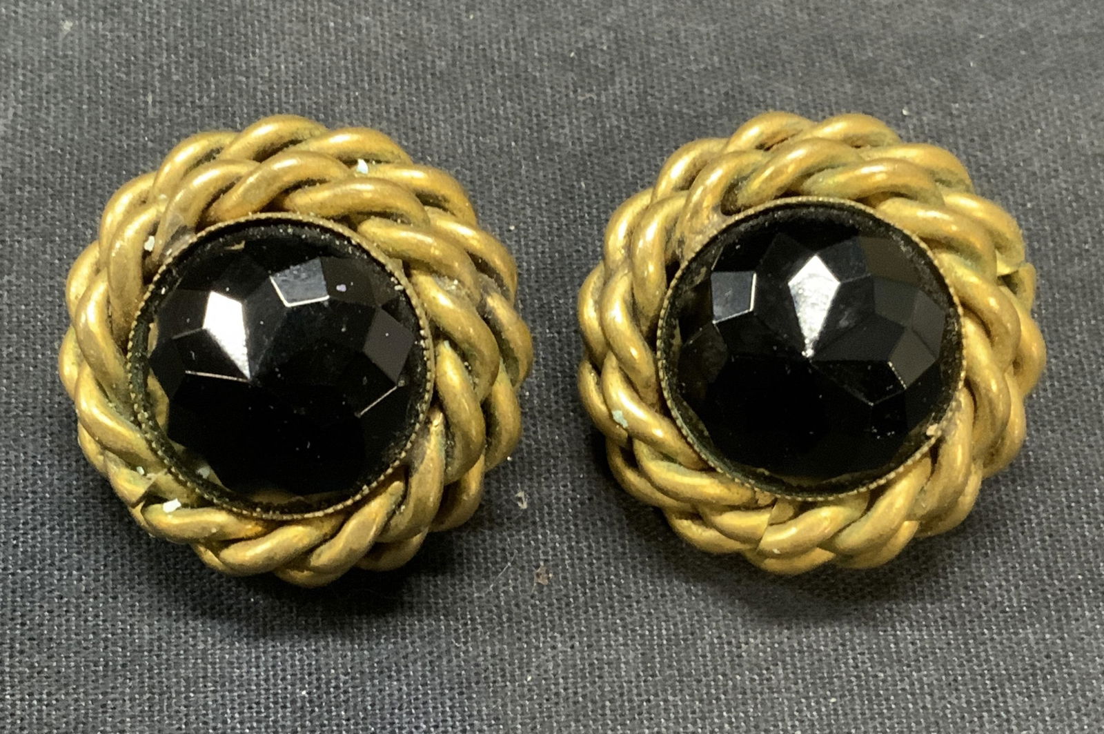 Vntg Butler & Wilson Gold Tn Crystal Earrings: Vintage Butler and Wilson gold tone twisted cable border and black crystal clip on earrings. Signed to underside. Measures approx. 1.25 inches diameter. Some scratching observed. Estate jewelry, costu