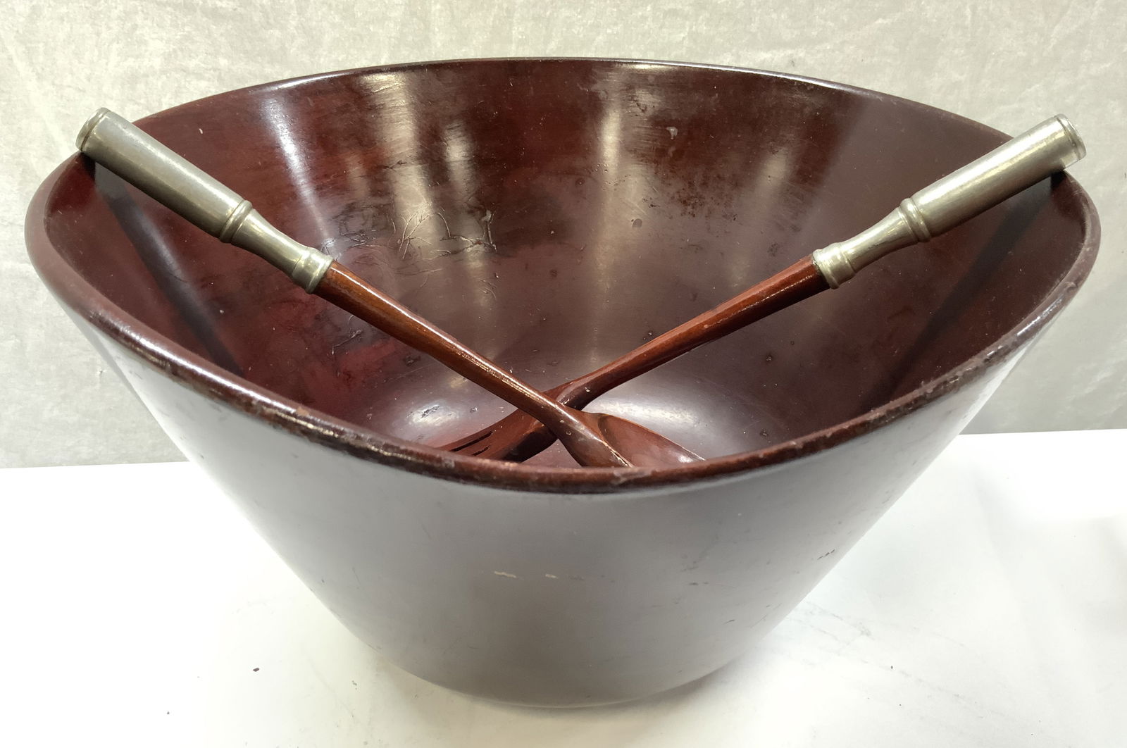 Wooden Salad Service Set W Silver Plate Handles: Lot includes 1 bowl, 1 serving spoon and 1 serving fork. Each piece is mahogany toned and wooden with semi gloss finish. Serving utensils have silver plate handles. Bowl measures approximately 13.25 i