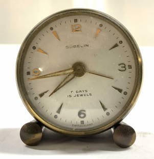 GUBELIN Floral Metal Desk Clock SWITZERLAND: Clock face reads GUBELIN SWITZERLAND. Clock is vintage and metal. Piece has multi toned floral & leaf detail to sides. Clock measures approximately 1.85 inches tall 1.75 inches wide 1 inch deep. Clock