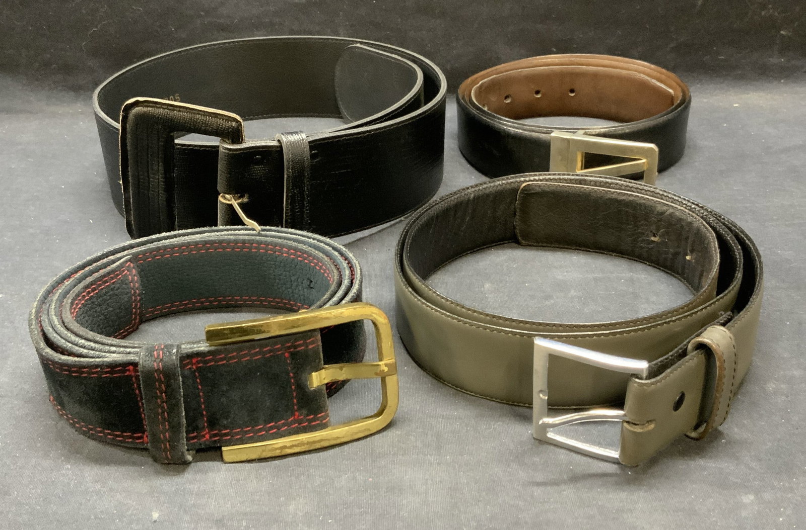 Lot 4 Chetta B & More Leather Belts: Lot of 4 black, gray, and blue leather and suede belts. Wide black belt signed Chetta B, gray belt signed Harness House. Longest belt measures approx. 45.5 inches. All belts have some wear to leather 