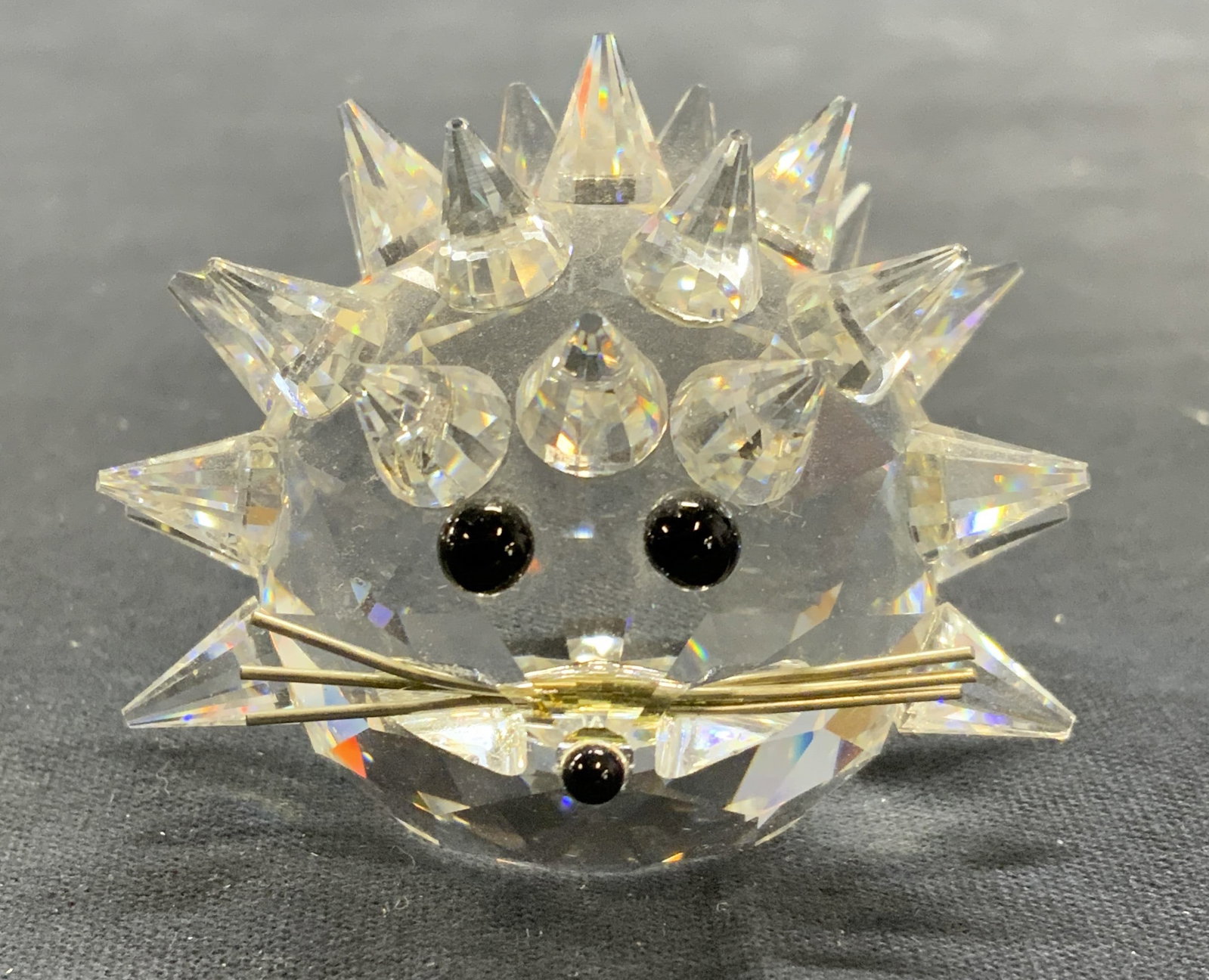 Vintage Swarovski Crystal Porcupine Figural: Vintage Swarovski Crystal porcupine figurine. Raised spike surface with wire and cabochon detail. Signed to underside. Measures approx. 2 inches wide. Some surface wear including scratching observed. 