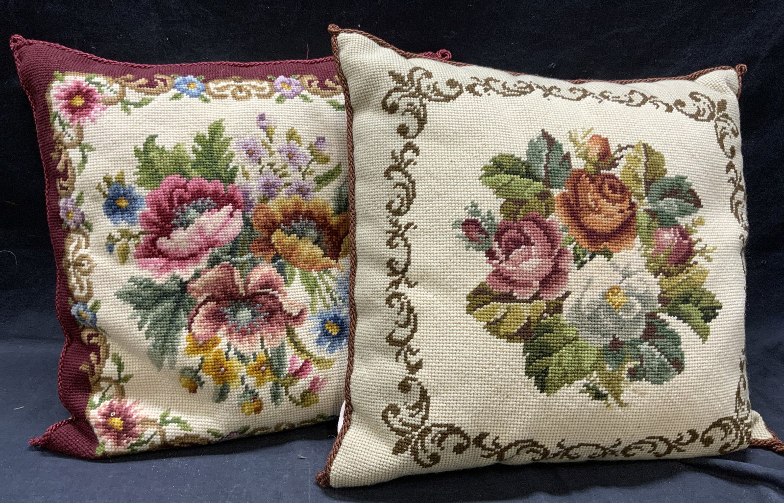 Lot 2 Vintage Needlepoint Pillows W Floral Details: Lot includes 2 pillows. Each are vintage & needlepoint. Pillows each have multi toned floral, leaf & scroll detail. Backsides of each pillow are cream toned. Includes 1 wine red toned & 1 cream toned.