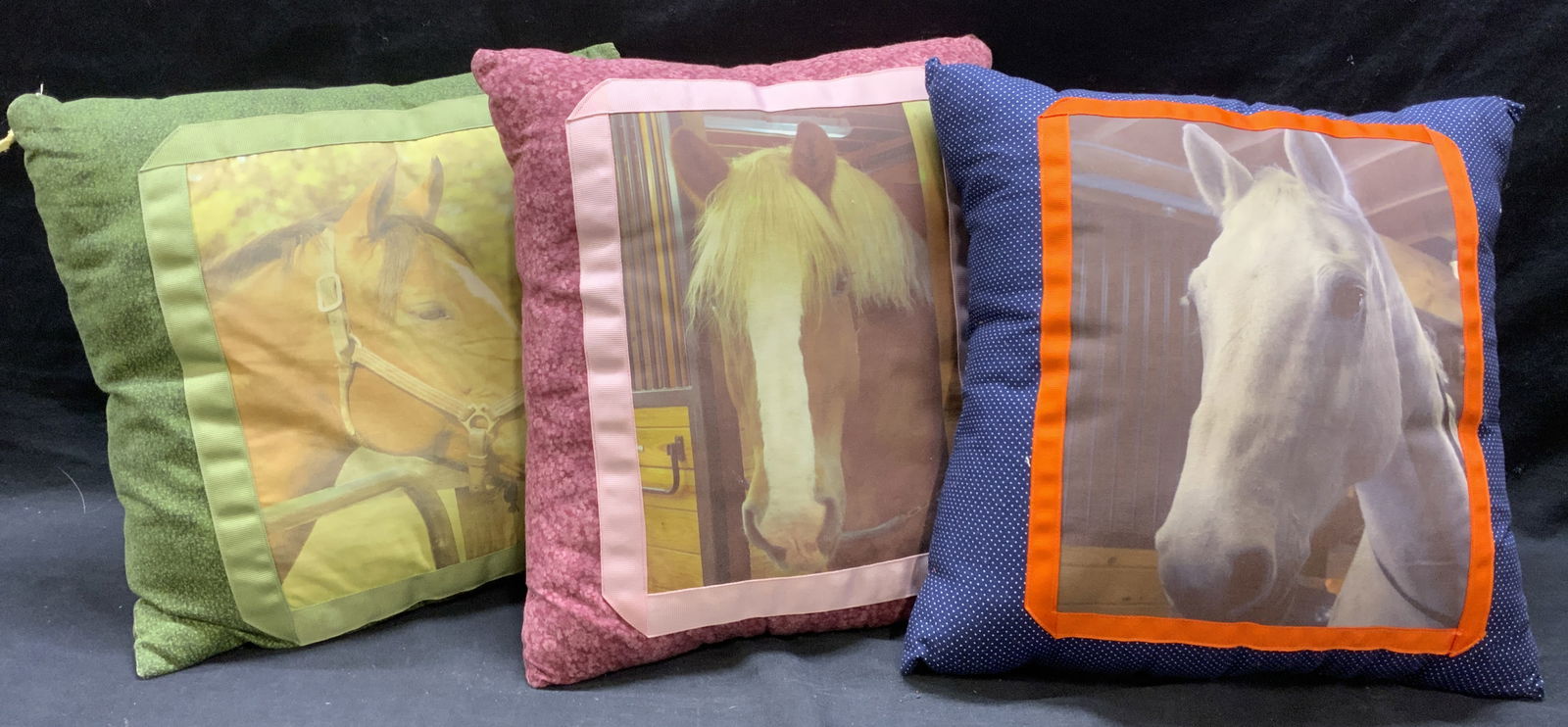 Lot 3 Vintage Horse Pillows: Lot includes 3 pillows. One is blue toned with white toned polka dot detail, one is maroon toned with floral detail. One is green toned with leaf pattern detail. Each pillow has printed images of hors