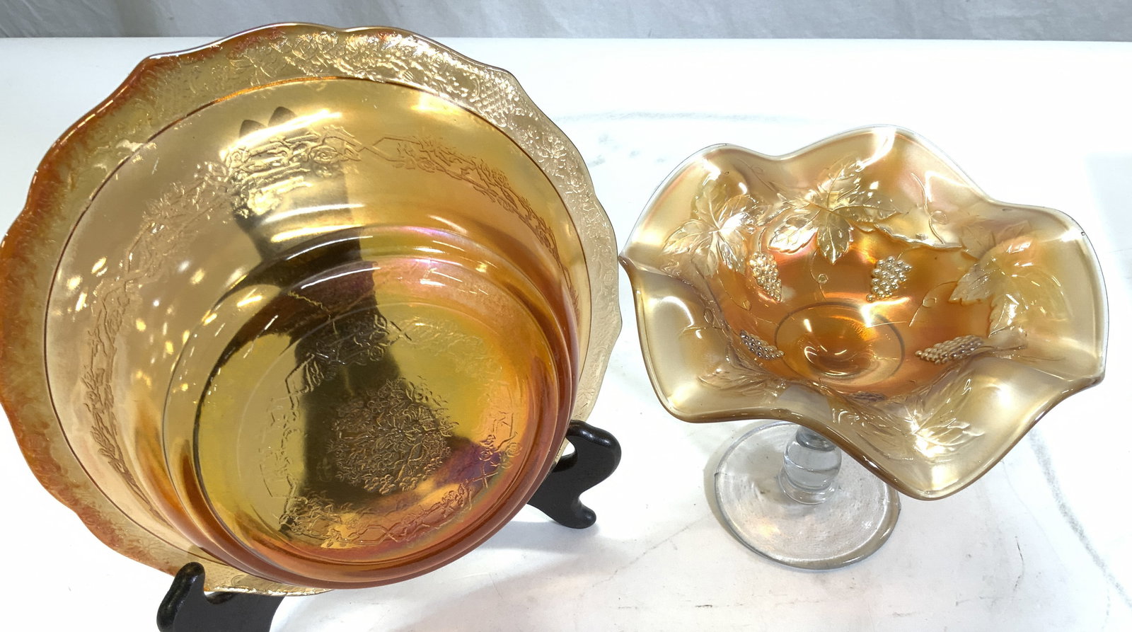 2 Tangerine Depression Glass Bowl & Tazza: Iridescent tangerine depression glass , bowl and furled rim tazza. Embossed designs. Bowl measures 8.5 in. Wide x 2.5 in. Ht. Tazza has a clear base and stem , grape vine motif furled bowl. Measures 6