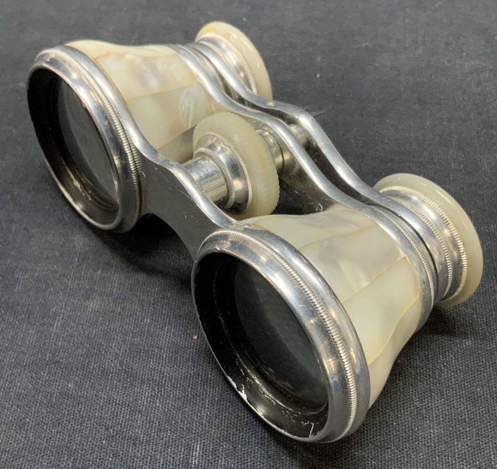 BIGELOW KENNARD Mother of Pearl Opera Glasses: Vintage mother of pearl and silver tone metal opera glasses. Rims read BIGELOW KENNARD & CO. BOSTON. Metal to center impressed with the word FRANCE. Measures approx. 4.25W x 2D x 1.75H in. Sone losses