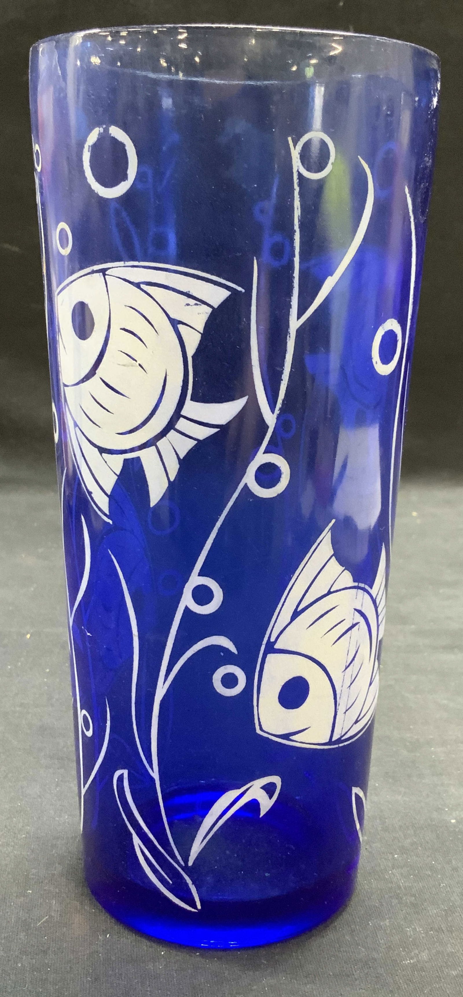Blue Glass Angel Fish Motif Vase: Blue glass vase with white angel fish motif. Measures approx. 3.75 x 8.25 inches. Some surface wear including scratching observed. Vase, blue vase, glass vase, fish vase, Angel fish vase, table decor