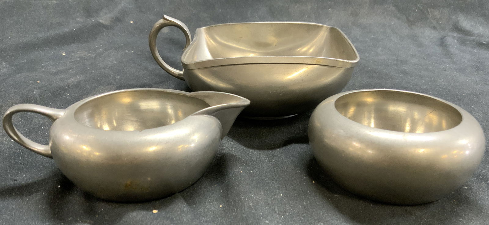 Royal Holland Pewter Lot 3 Vessels: Underside of each piece is inscribed ROYAL HOLLAND PEWTER MADE IN HOLLAND. Lot includes 3 vessels (1 circular without handles, 1 creamer dish with handle, & 1 rounded corner dish with handles. Largest