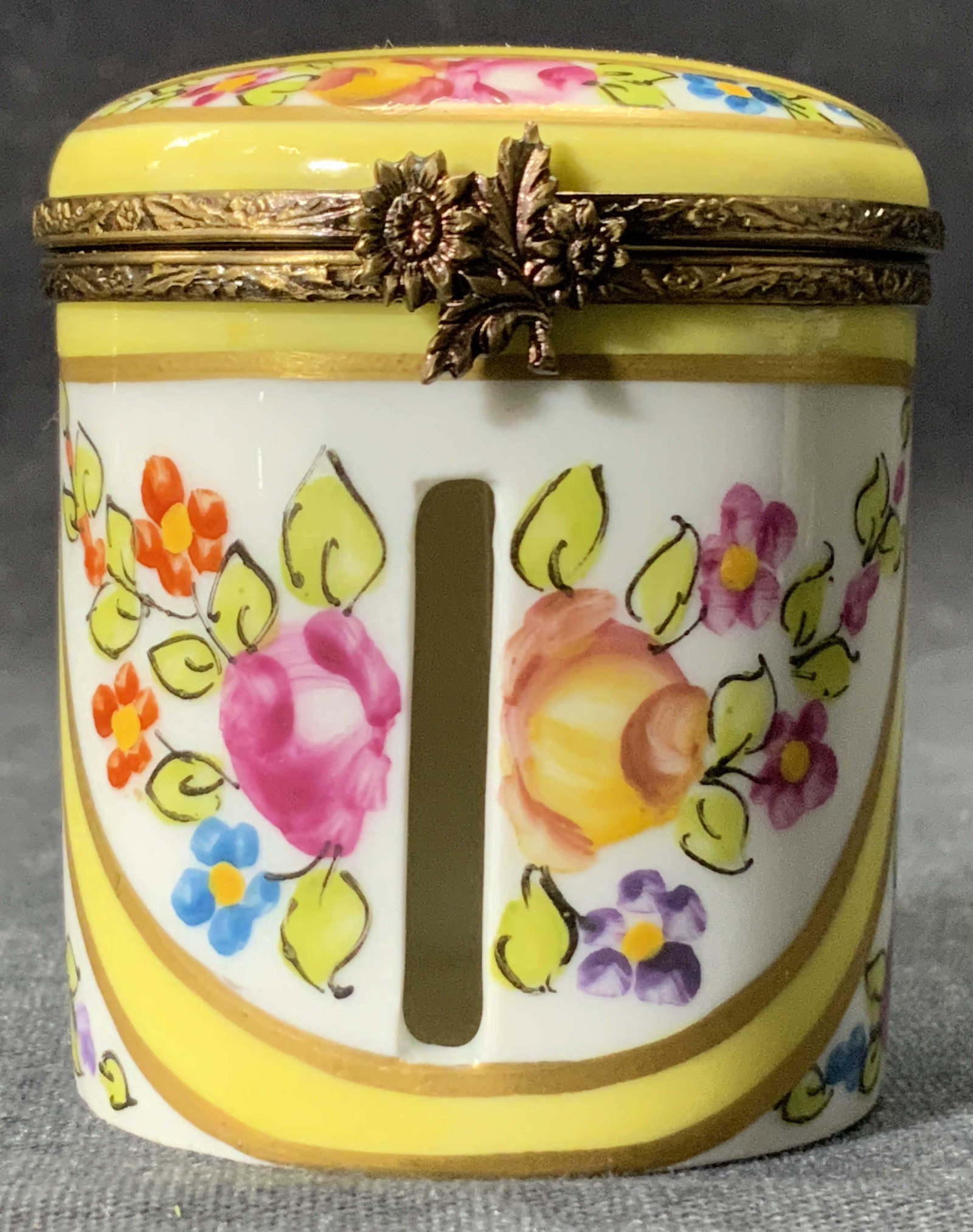 LIMOGES FRANCE Hand Painted Porcelain Pill Box: A vintage hand painted French porcelain pill box. Primarily painted yellow hues with florals throughout. Pierced porcelain detail to the obverse. Piece opens with metal hinge hardware which features a