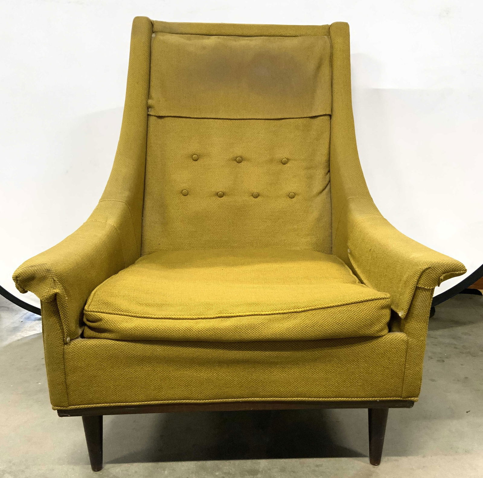 MILO BAUGHMAN Style MCM Uph Lounge Chair: Chair is MILO Baughman Style . Piece has olive toned upholstery. Chair has brown toned wooden tapered legs. Backrest has tuft buttons. Chair has sloping arms. Piece measures approximately 38 inches ta